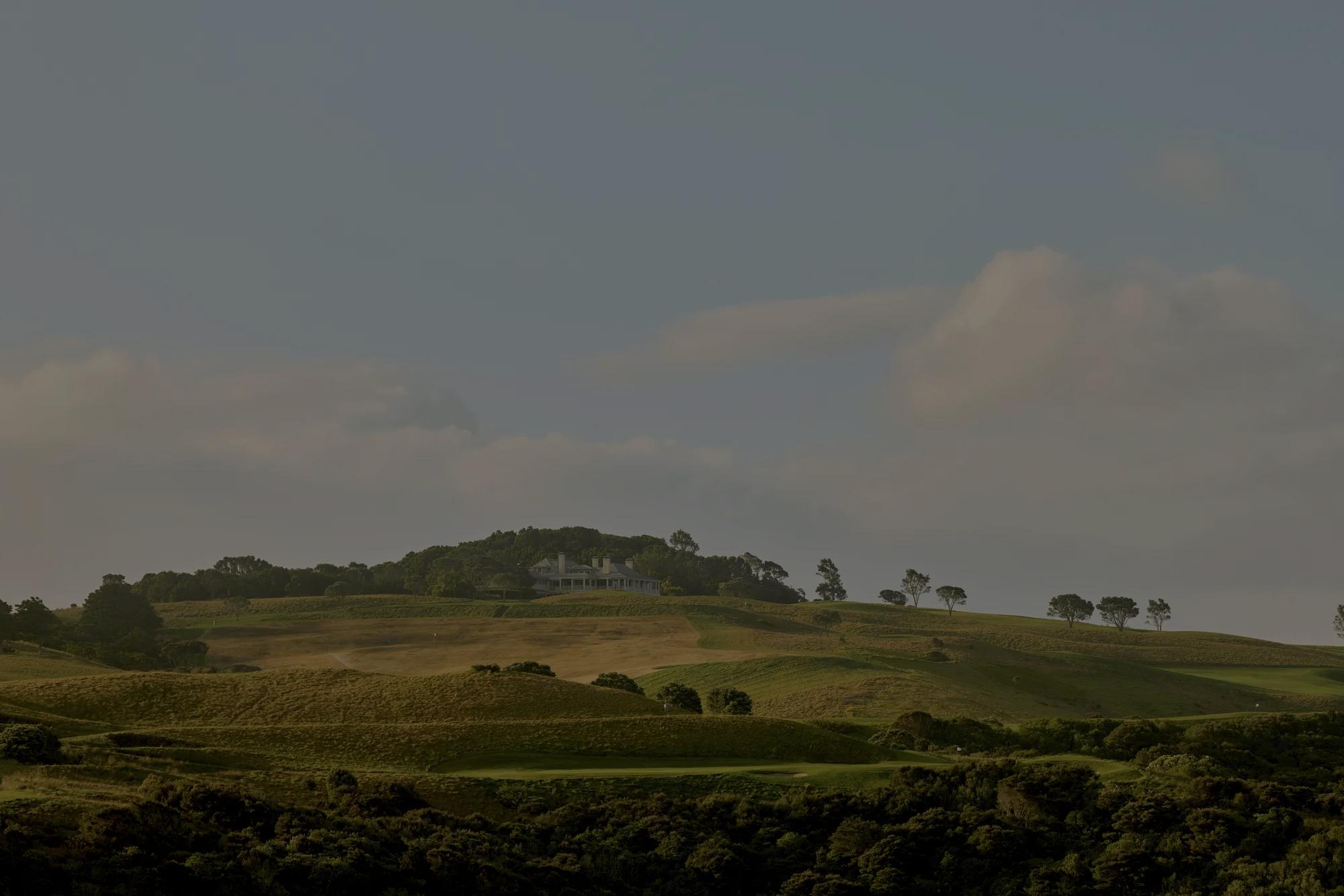 Distant view of the lodge at Rosewood Kauri Cliffs with the golf course in the foreground. 