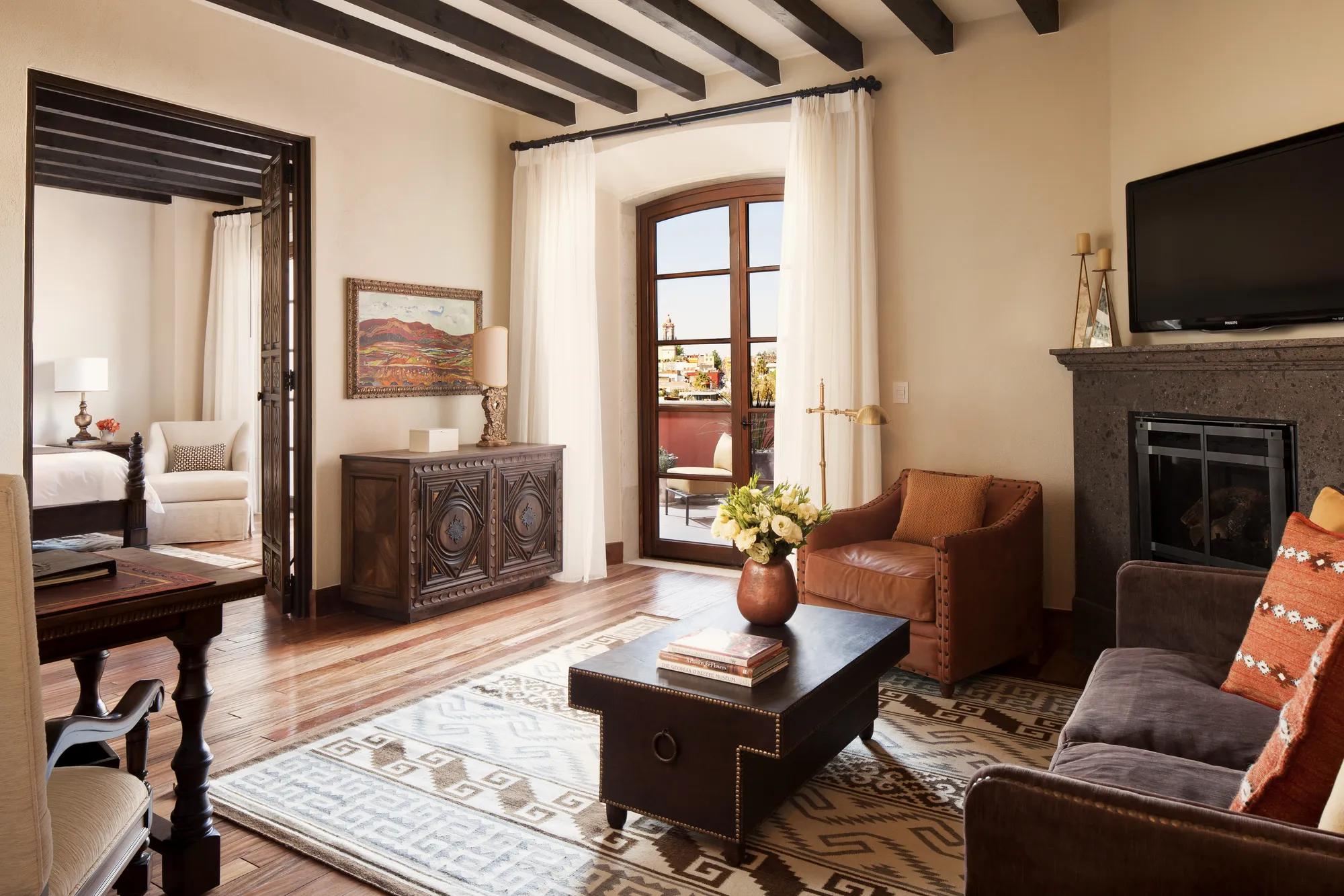 Parroquia Suite at Rosewood San Miguel de Allende featuring a separate bedroom, living area, fireplace, and terrace with views of the iconic parish. 
