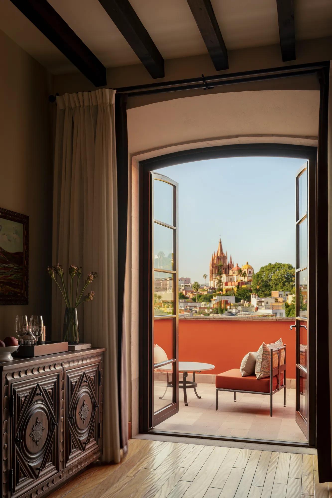 Parroquia Suite at Rosewood San Miguel de Allende featuring a separate bedroom, living area, fireplace, and terrace with views of the iconic parish. 
