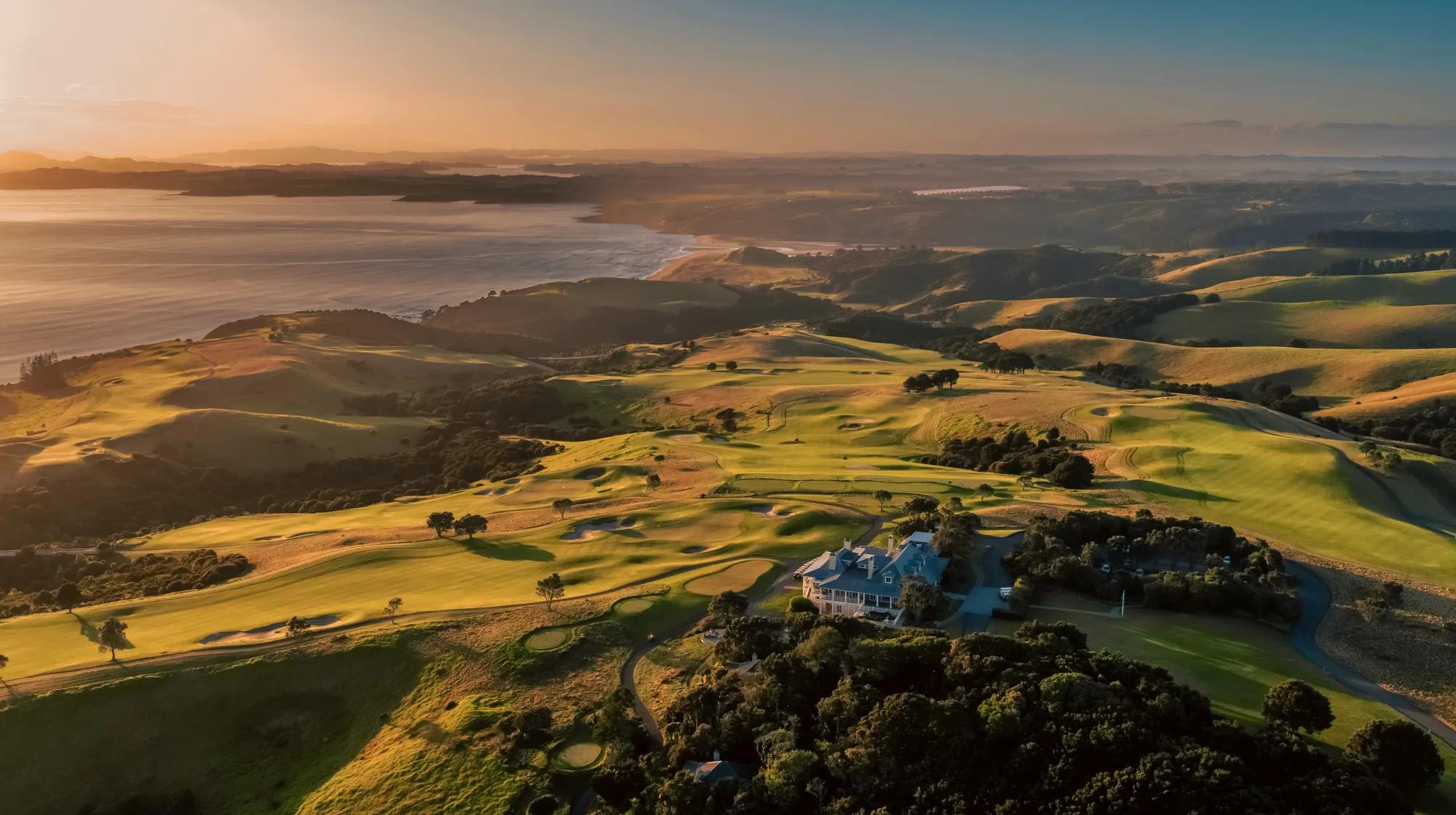 Stunning aerial view of the Kauri Cliffs lodge and golf course, sprawling across the landscape to the coastline. 