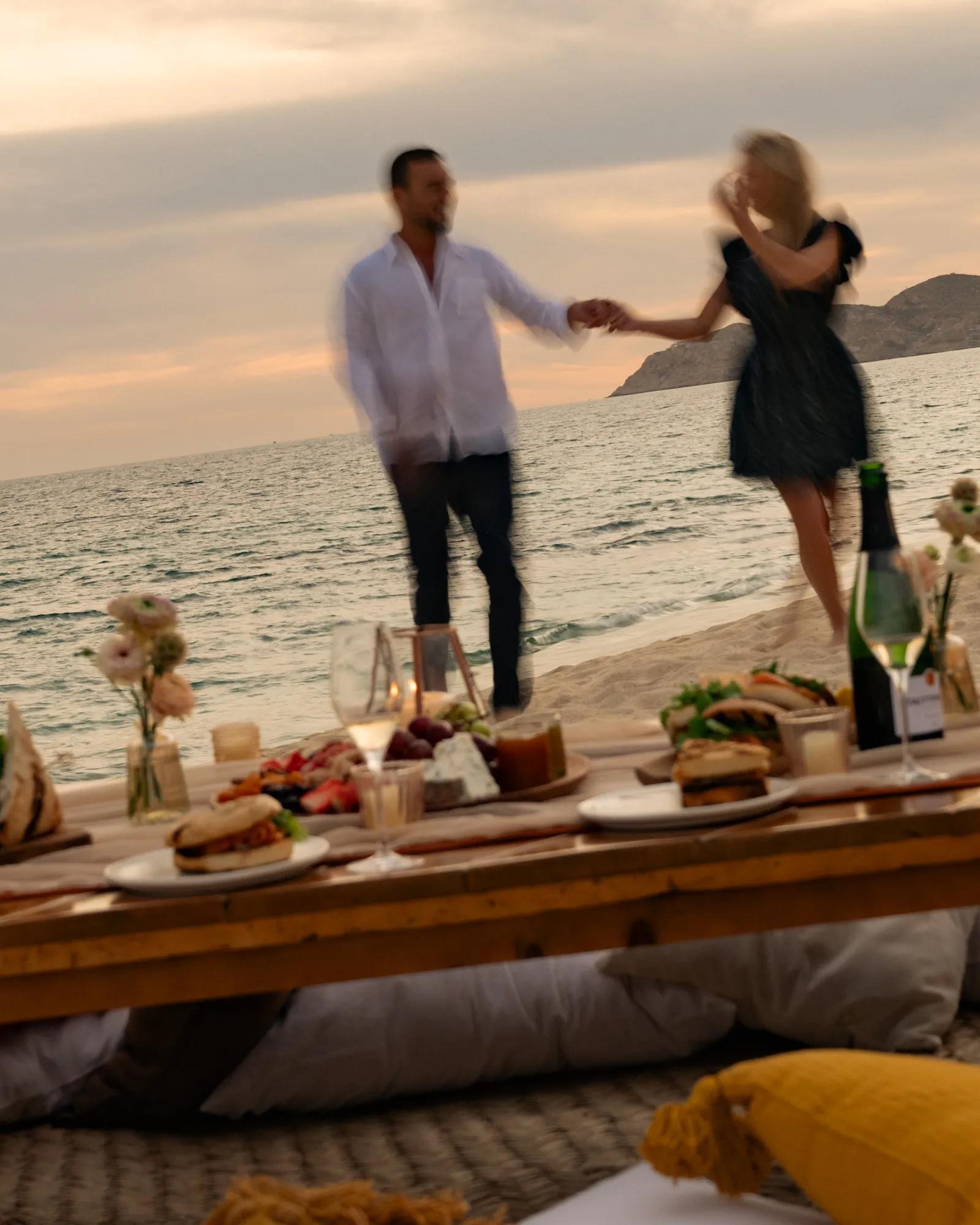 Beachfront resort with thatched-roof structures, an infinity pool, and lounge chairs overlooking the ocean under a clear blue sky