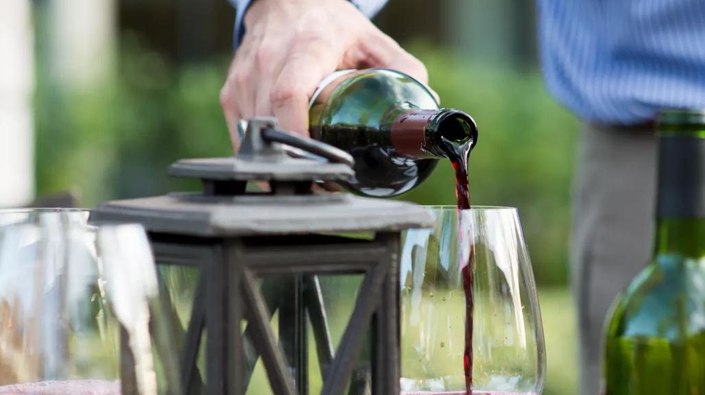 wine being poured into a glass on a table at Mount Eden Vineyard