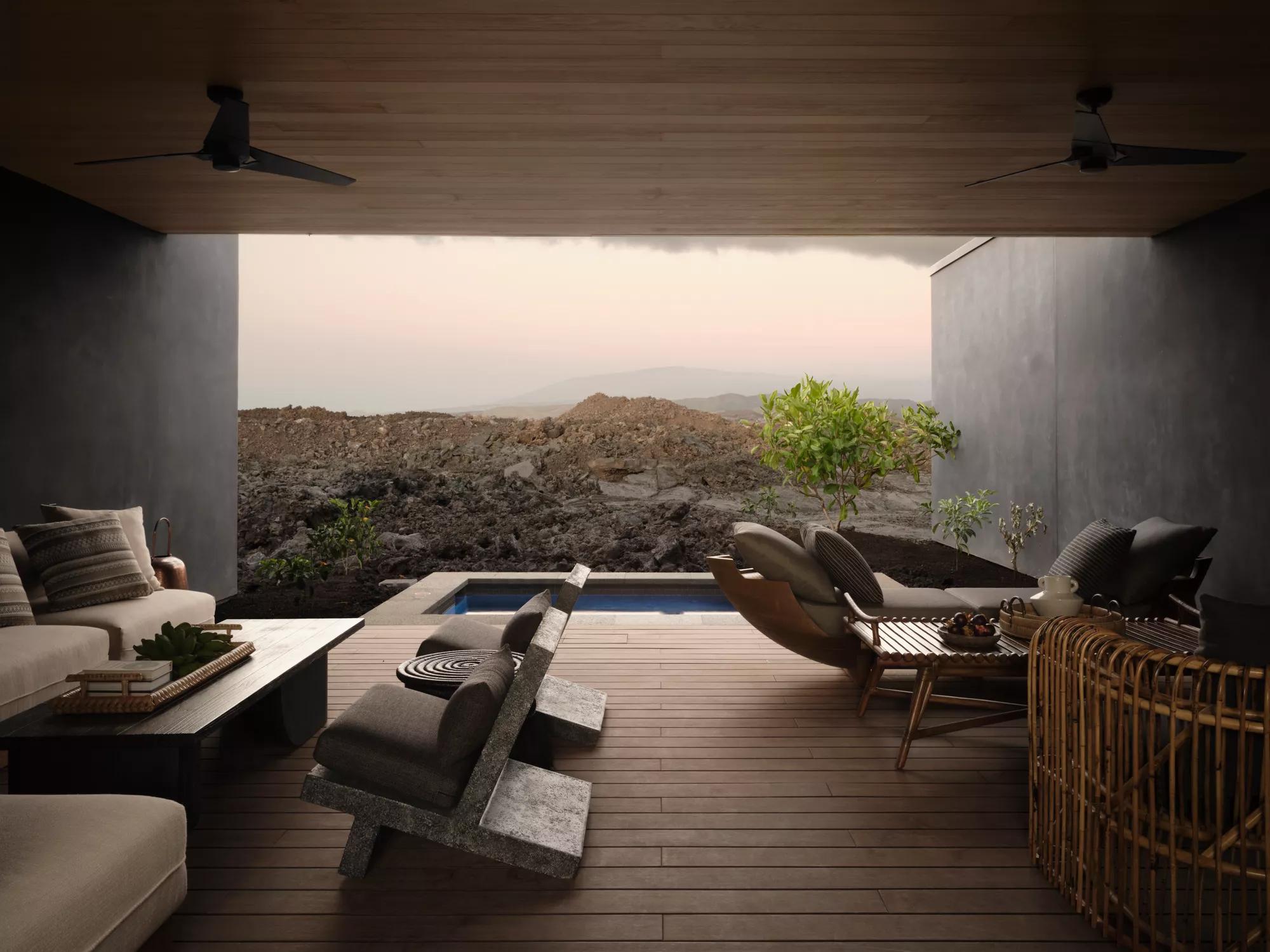 Open-air spa lounge with plunge pool, tables and seating.