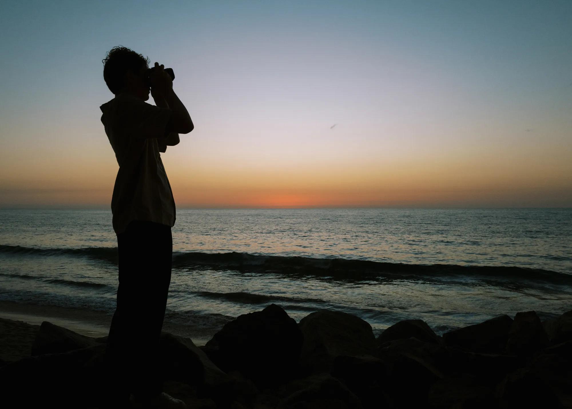 Child looking out the sunset and ocean