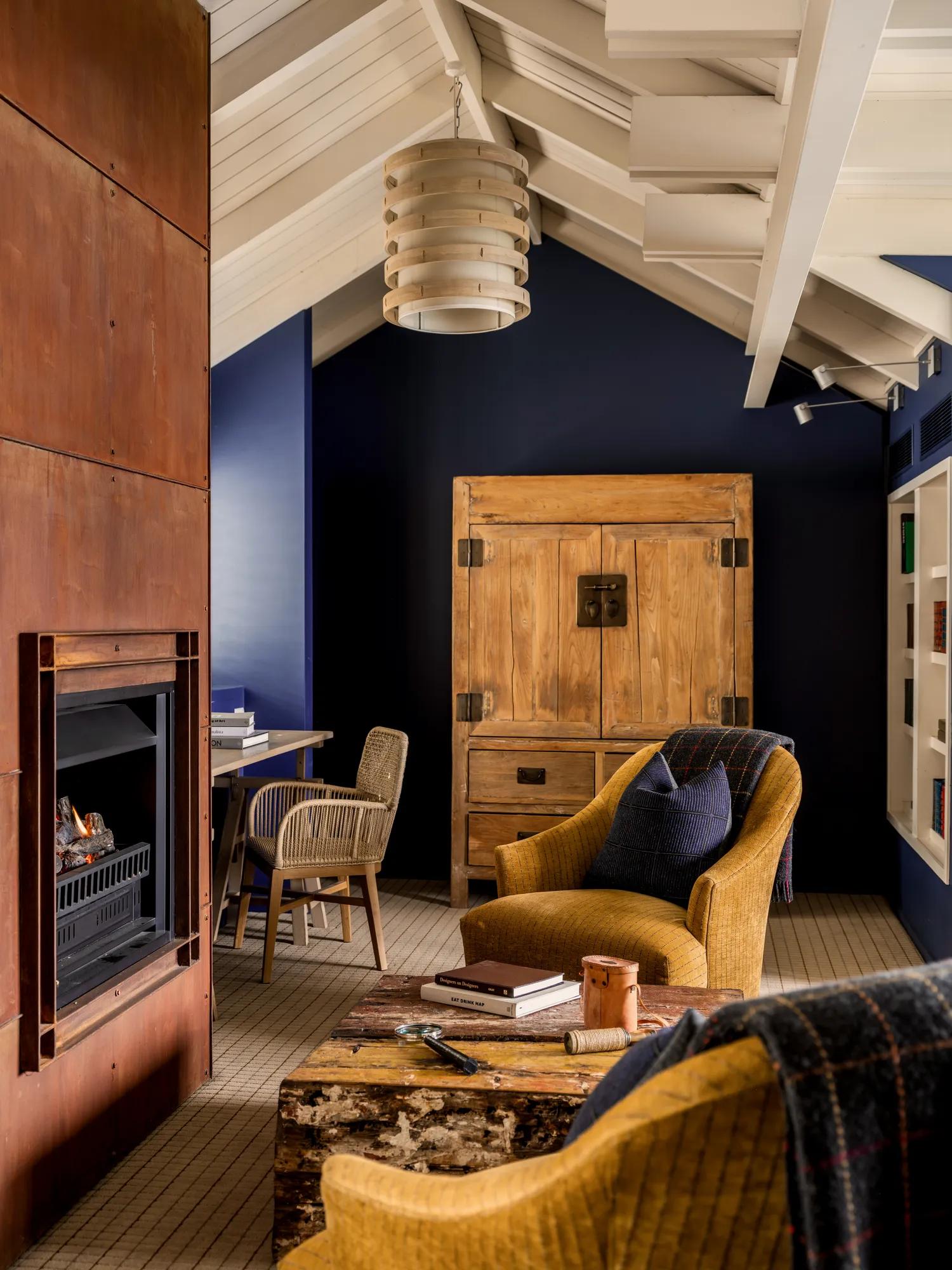 Cosy fireside setting next to a Corten steel fireplace in the Librabryt at Rosewood Matakauri. 