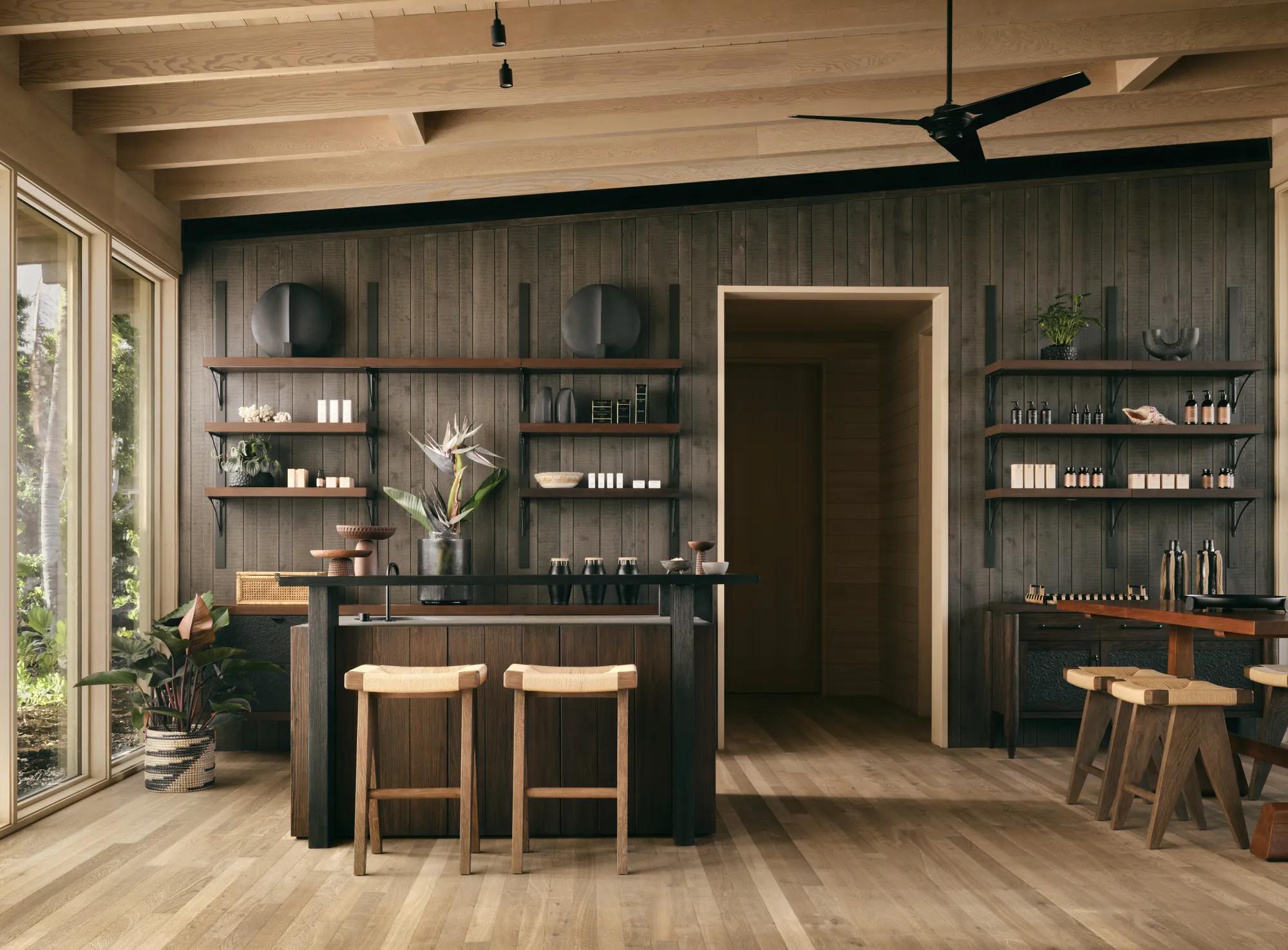 A spa lobby area with a table, sofa and chairs and shelves with spa products 