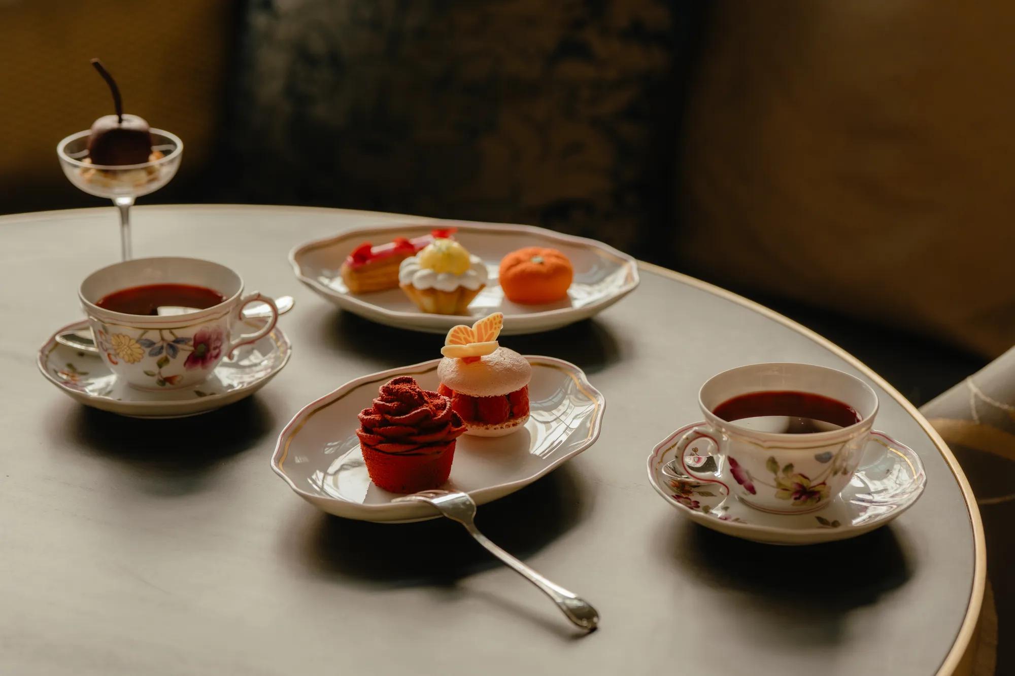 Table with tea cups and colorful pastries