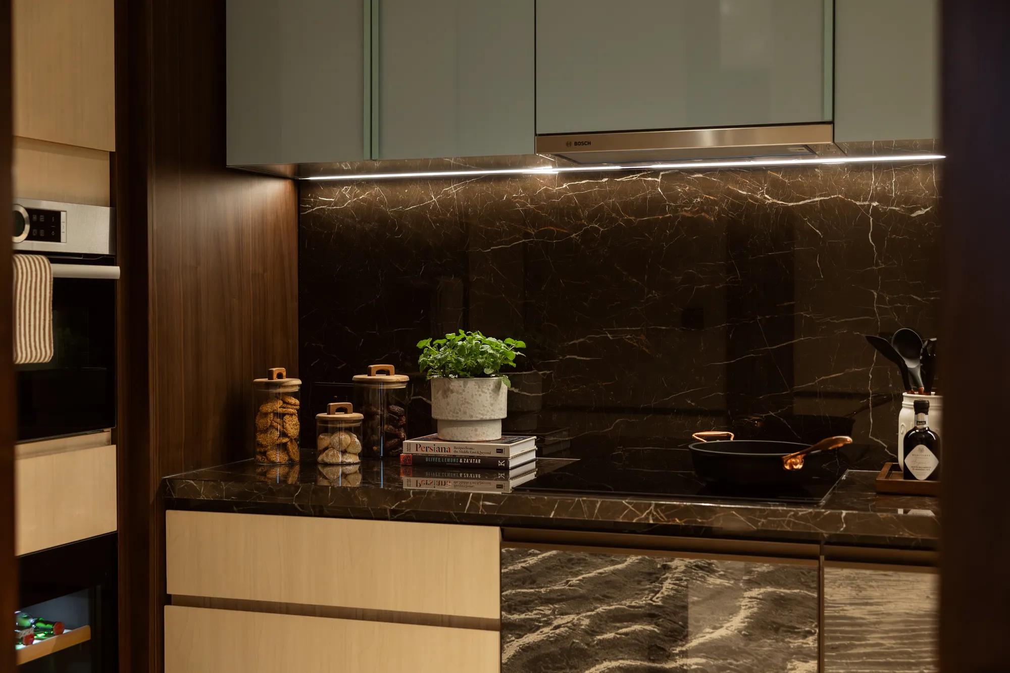 A collection of kitchen utensils are displayed on a wooden surface. The utensils include whisks, spoons, and spatulas.