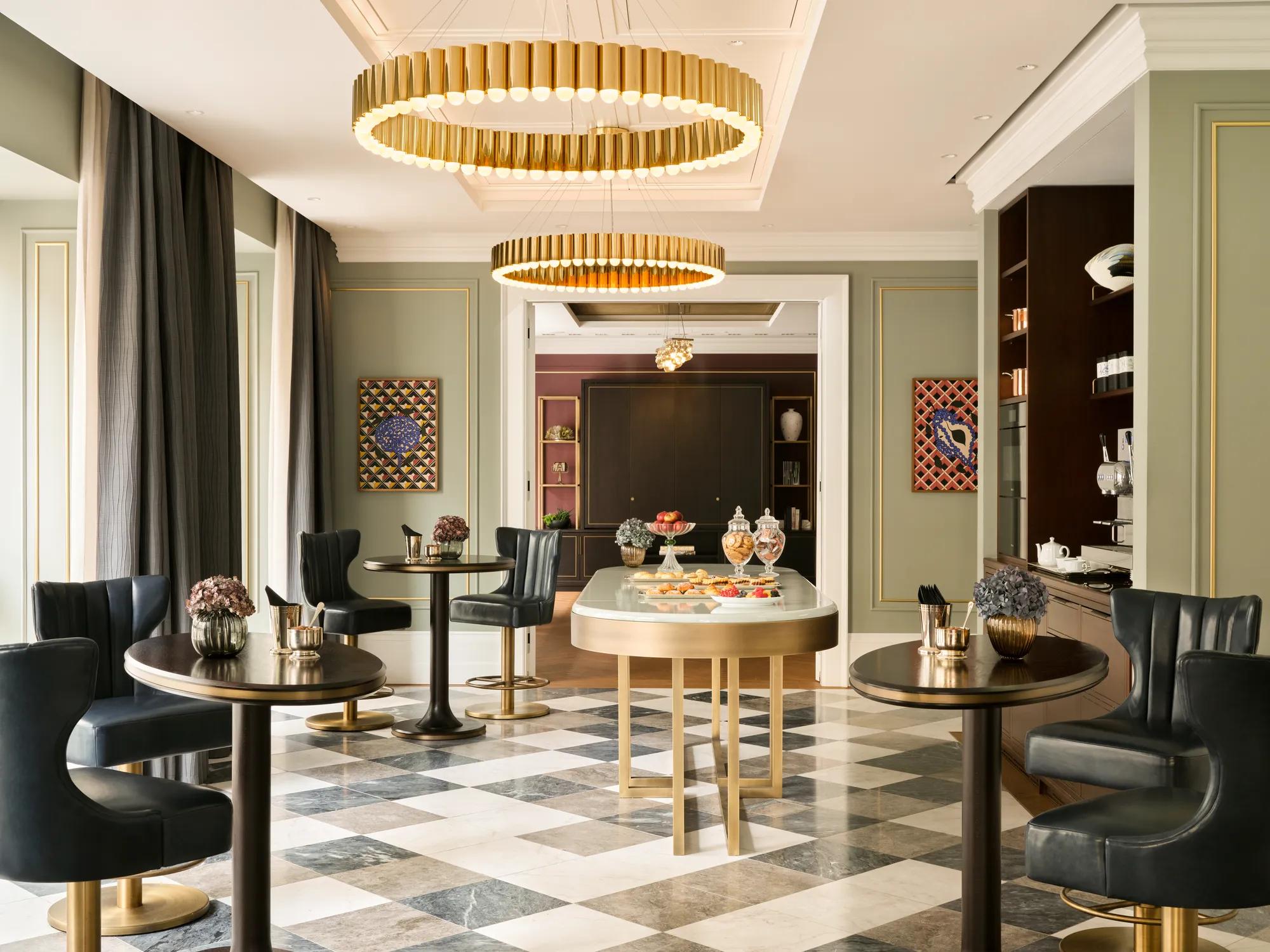 Elegant event space at Rosewood Vienna with blue paneled walls, large windows, round dining tables set for a formal gathering, and contemporary lighting accents.