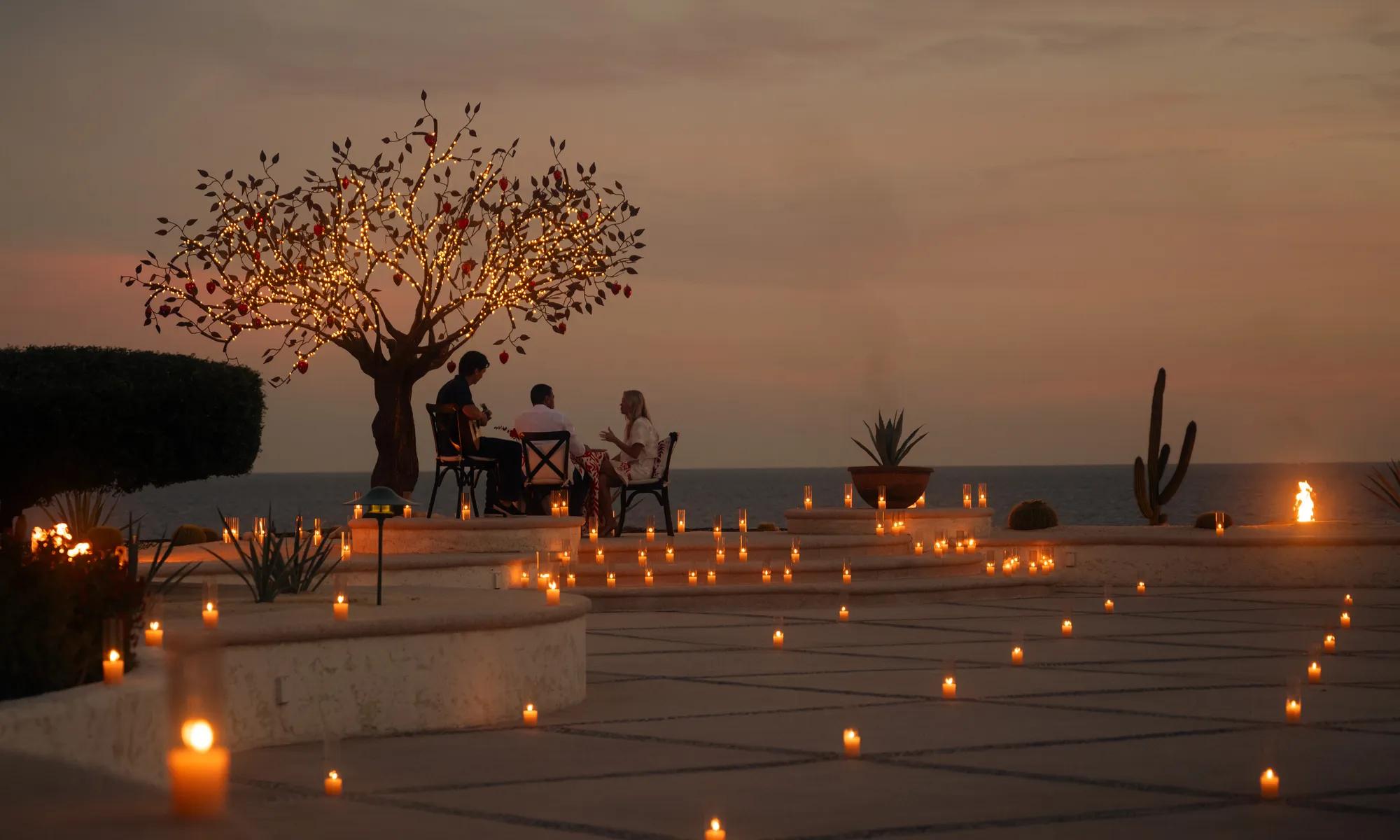 Couple enjoying the sunset at the beach with beautiful outdoor lounge with a table fullfilled of mexican delights