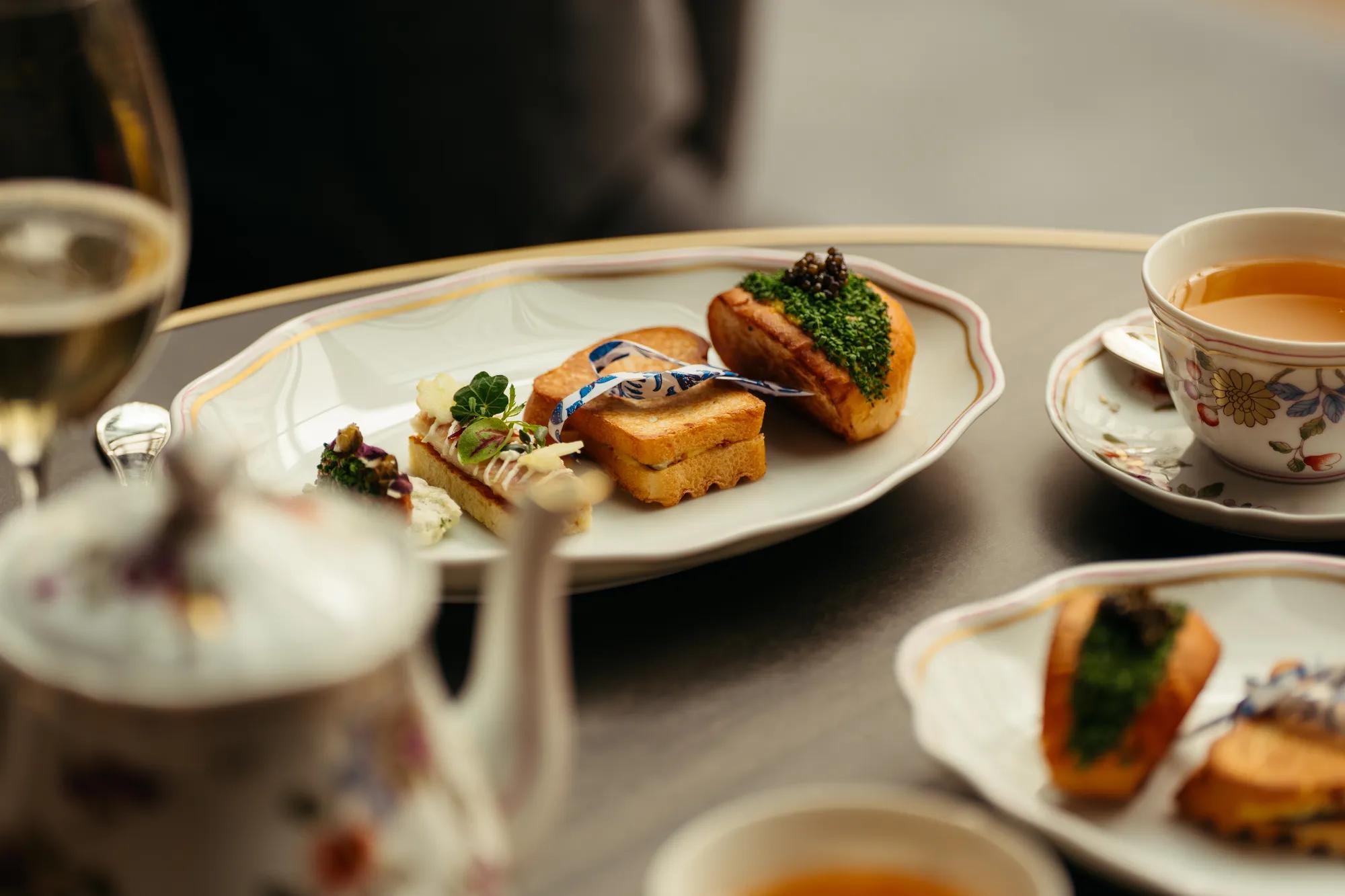 sandwiches and salty food on a table with tea