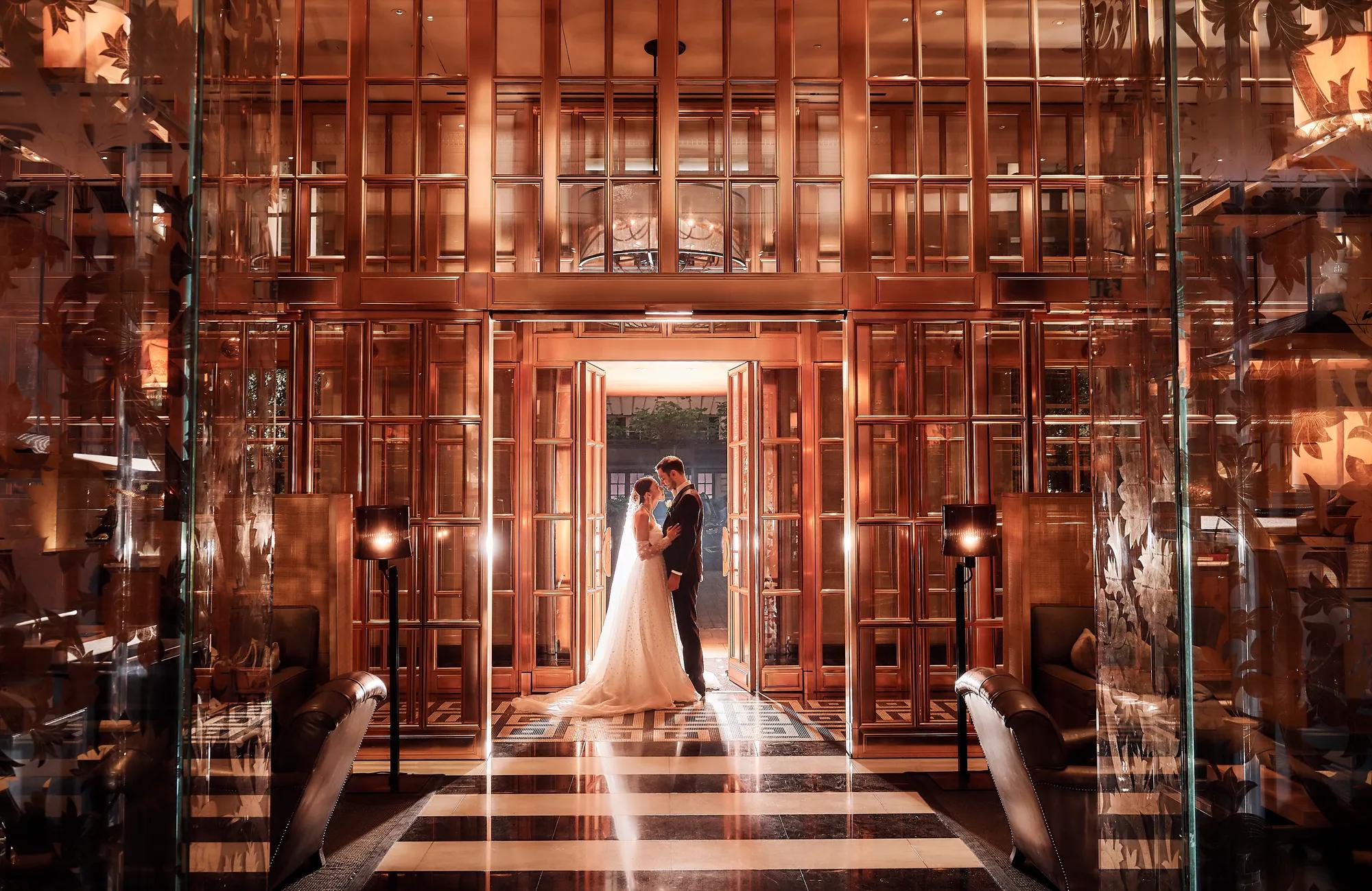 Married couple walking down the marble staircase at Rosewood London, a luxury London hotel based in Holborn.