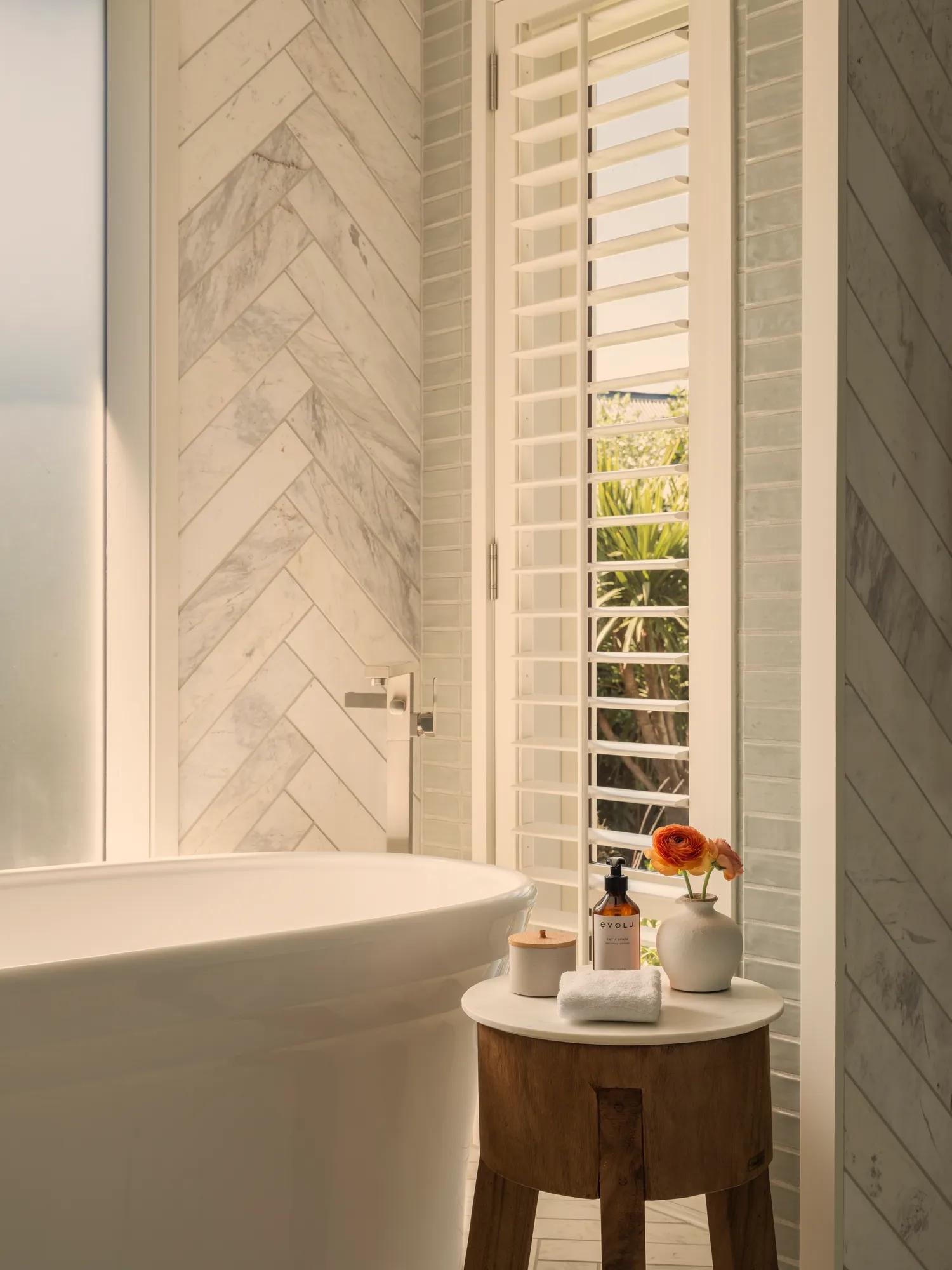 Modern, tiled luxury villa bathroom with a relaxing deep soaking tub