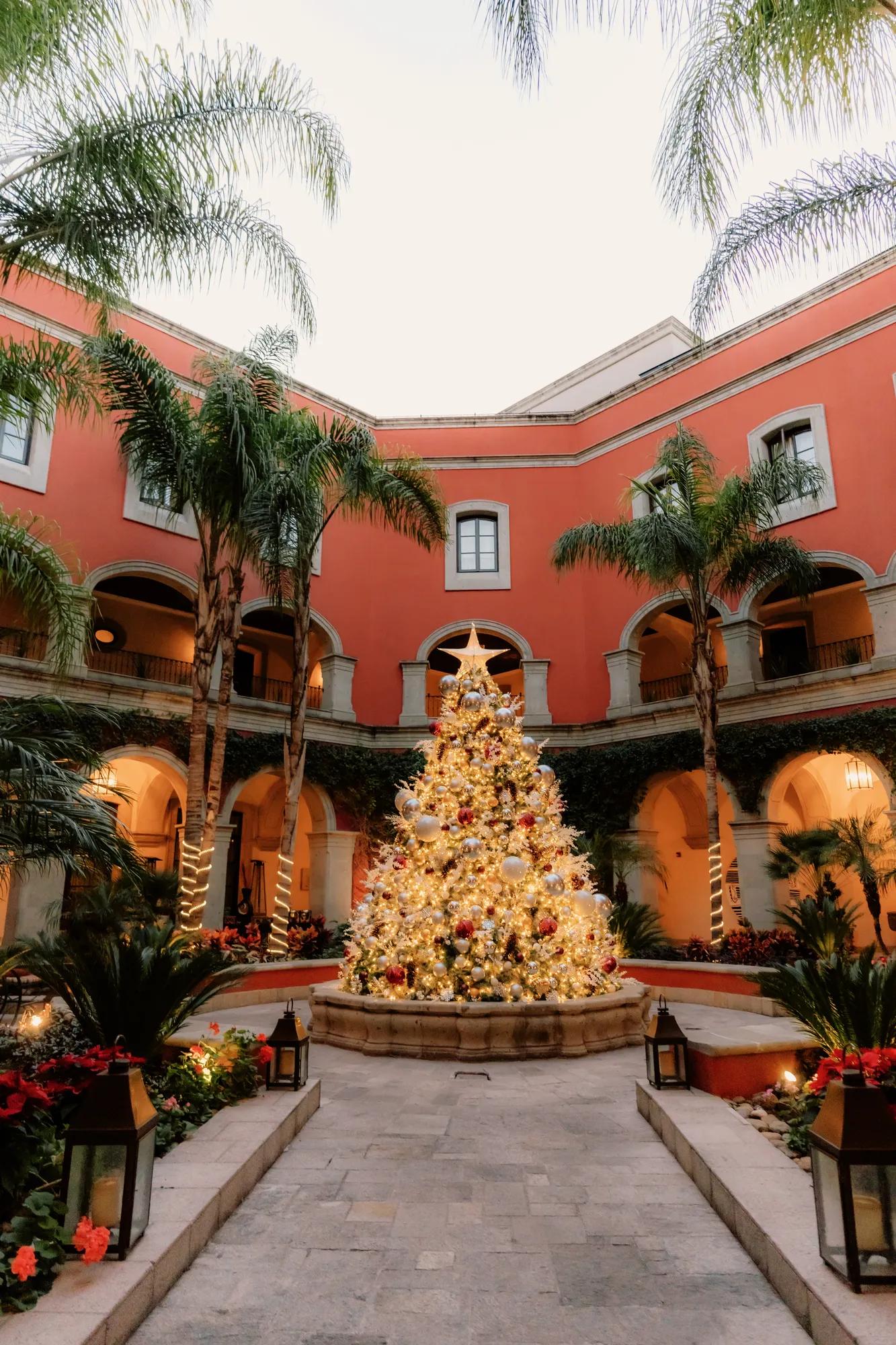 Christmas tree illuminated in the courtyard of the hotel, surrounded by the historic walls of the property in San Miguel de Allende.