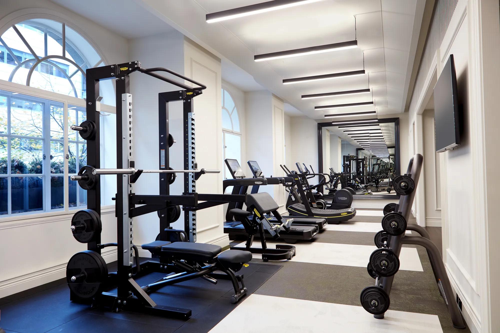 Strength and cardio equipment including free weights and treadmills in the fitness suite at Rosewood London