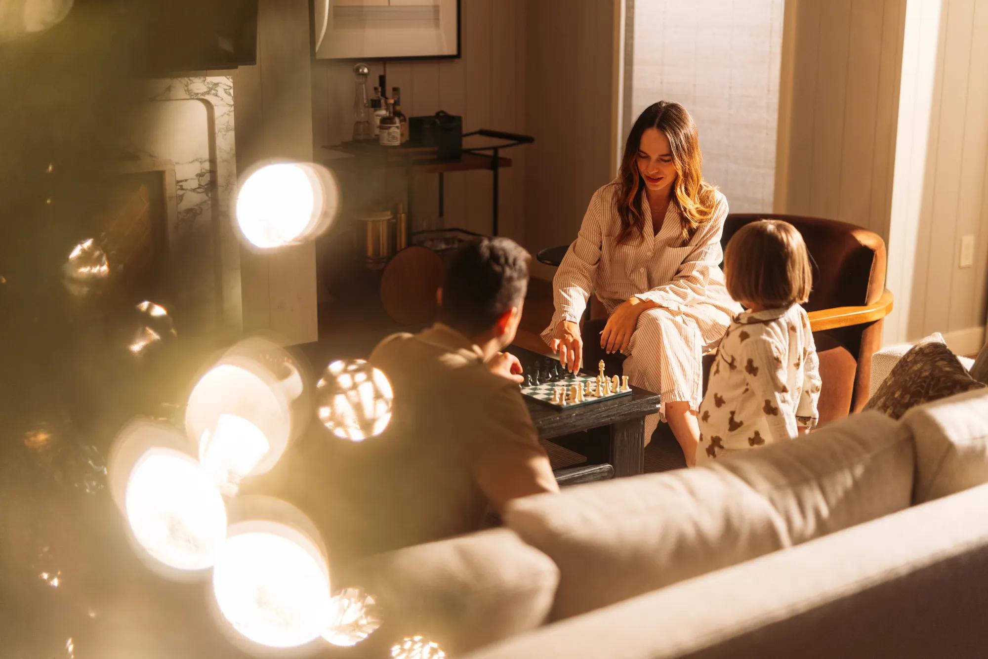 Family playing chess in the living room of a luxury villa at Rosewood Sand Hill.