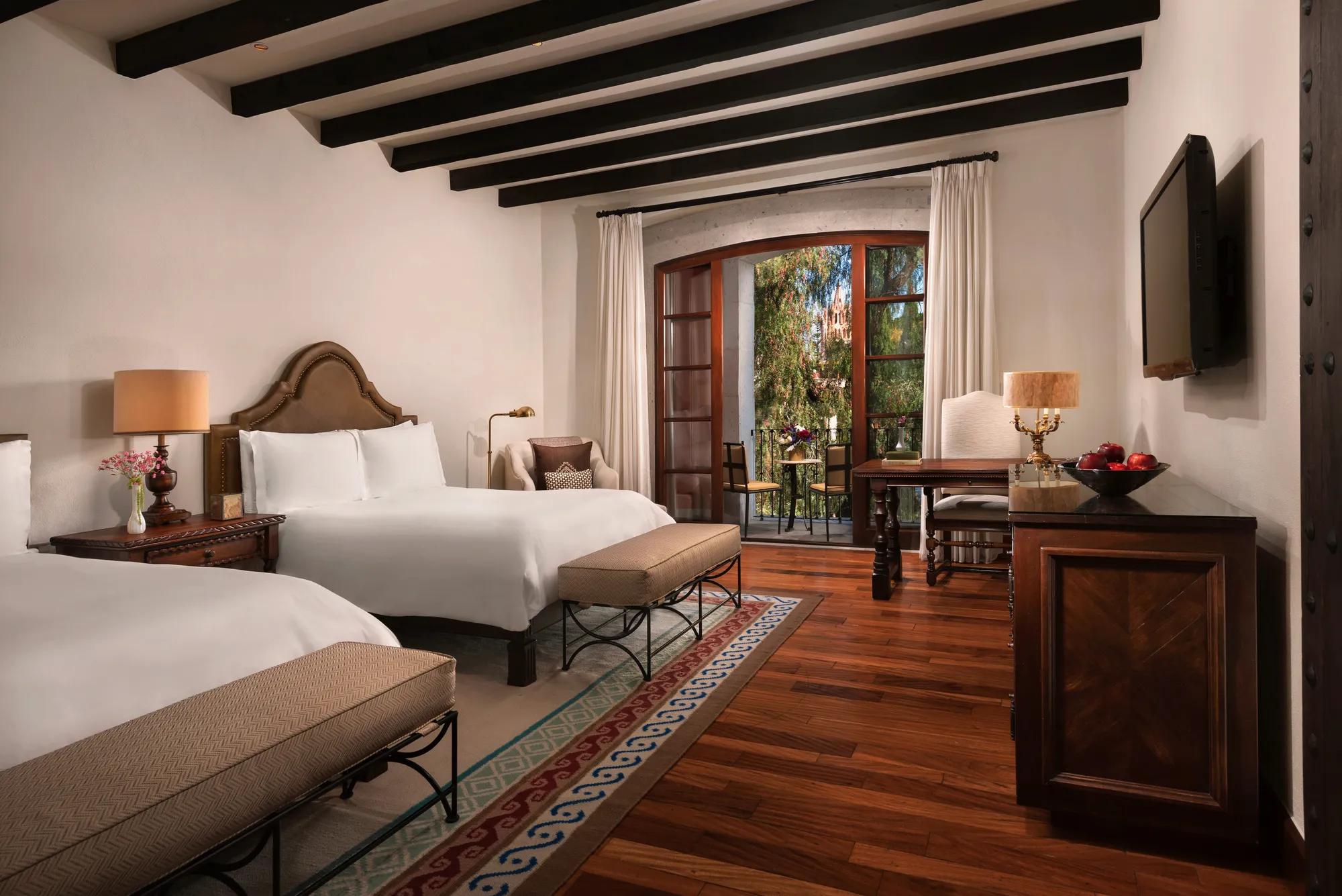 Elegant Colonial Room at Rosewood San Miguel de Allende featuring a king bed, handcrafted furniture, private balcony, and warm natural light.