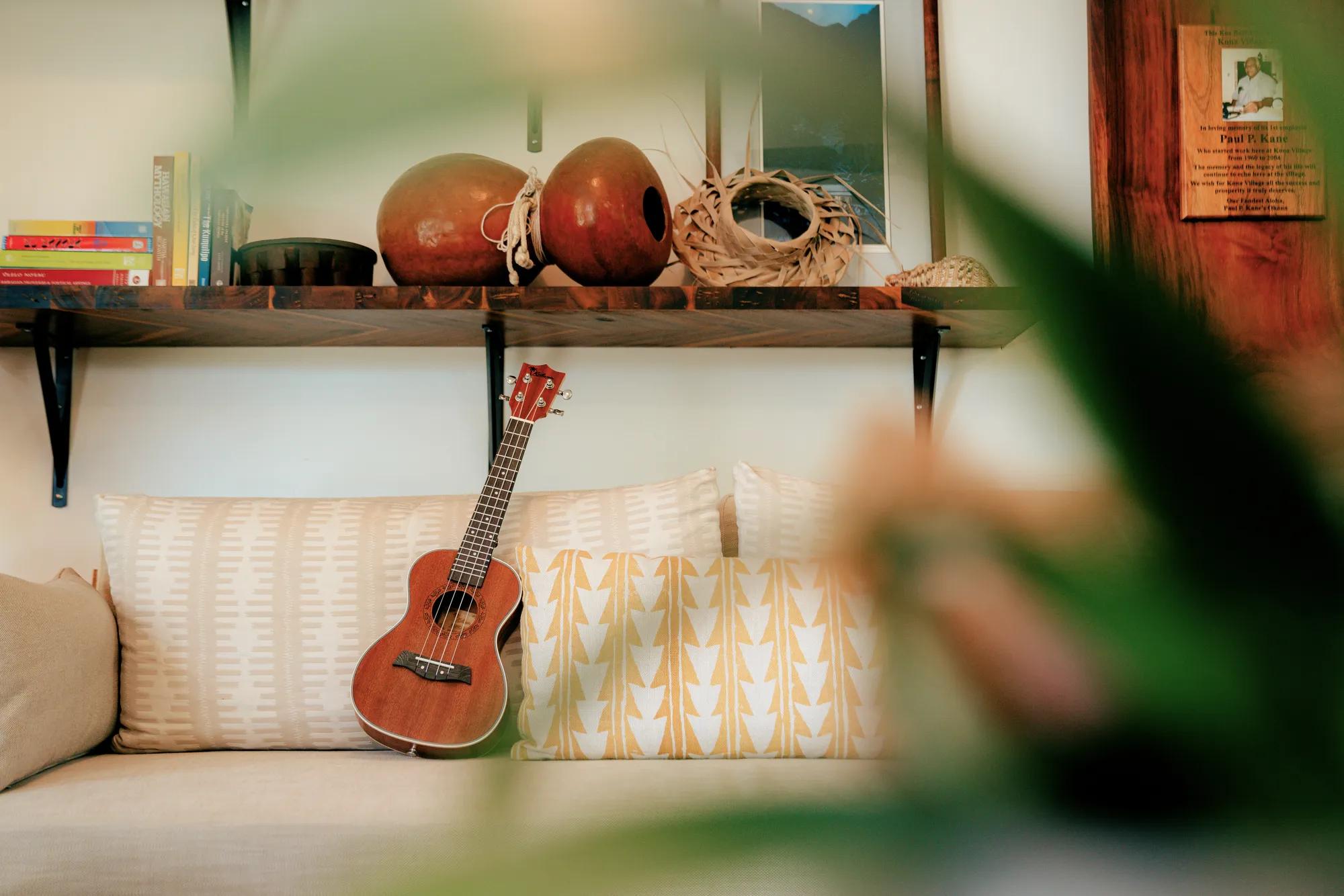 Ukulele sitting on couch with foliage in the foreground