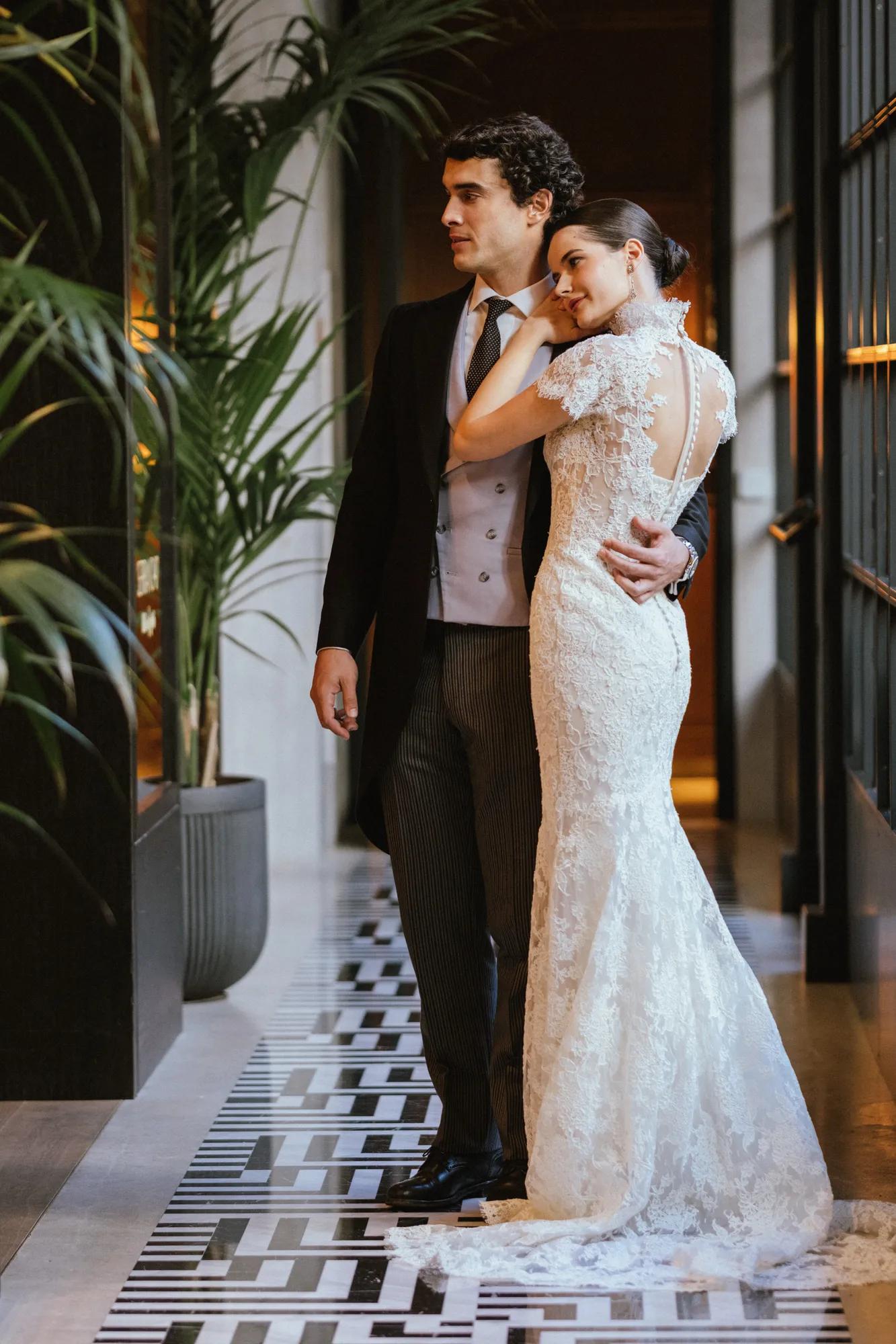 A couple embracing on their wedding day in the corridor of Rosewood Villa Magna in Madrid