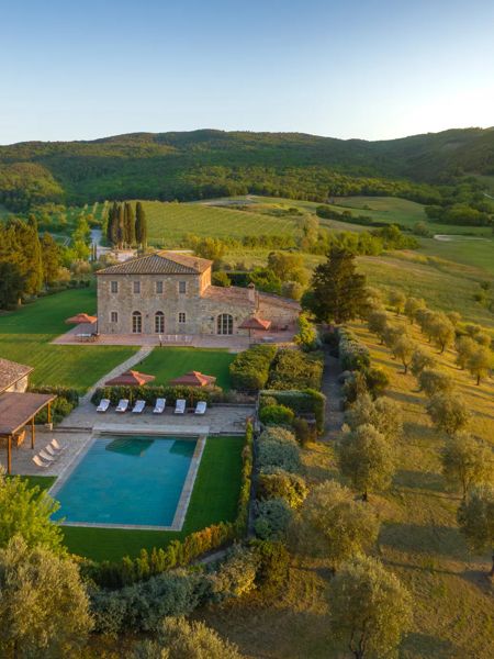 Spazio living esterno di una villa di lusso toscana con vista sulla campagna.