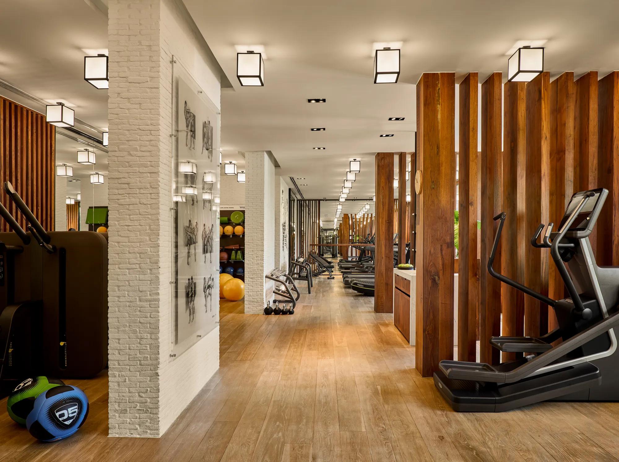 Infinity pool and jacuzzi at a luxury hotel with sun loungers and panoramic views of a golf course and out to the Pacific Ocean.