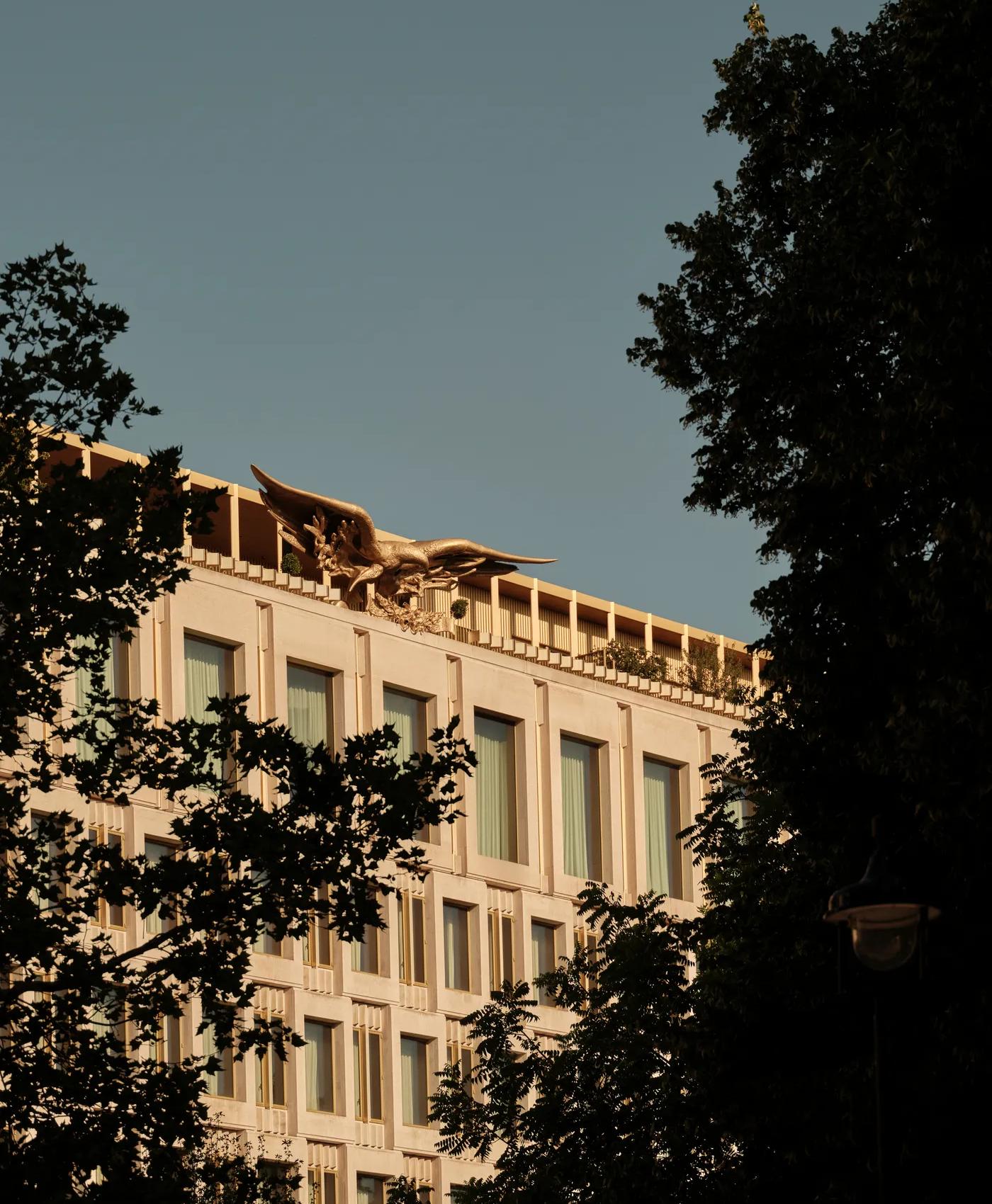 The Chancery Rosewood hotel facade with bronze eagle sculpture on the rooftop