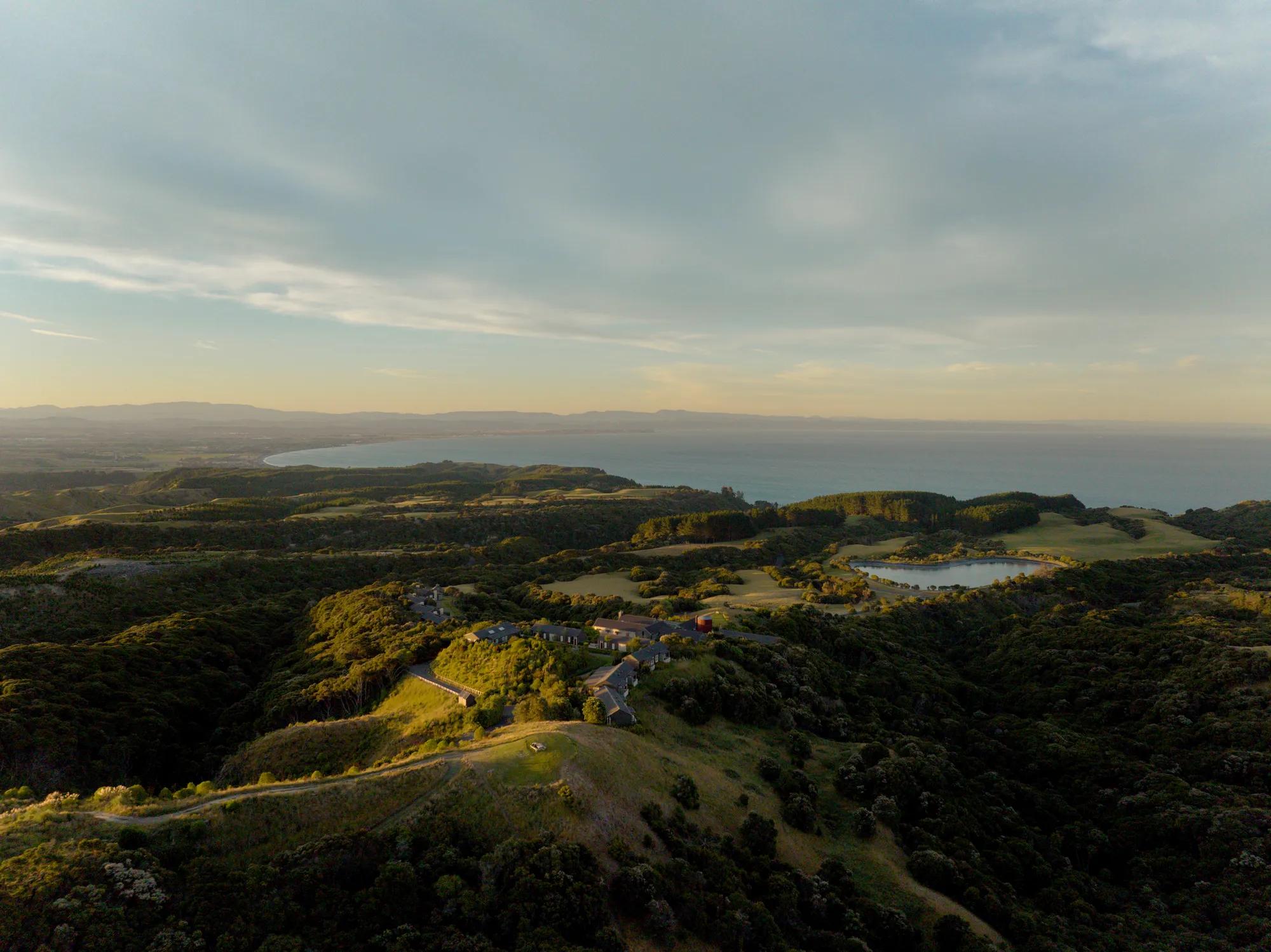 Aerial shot of the Rosewood Cape Kidnappers property with the ocean and Hawke’s Bay behind stretching of into the distance.