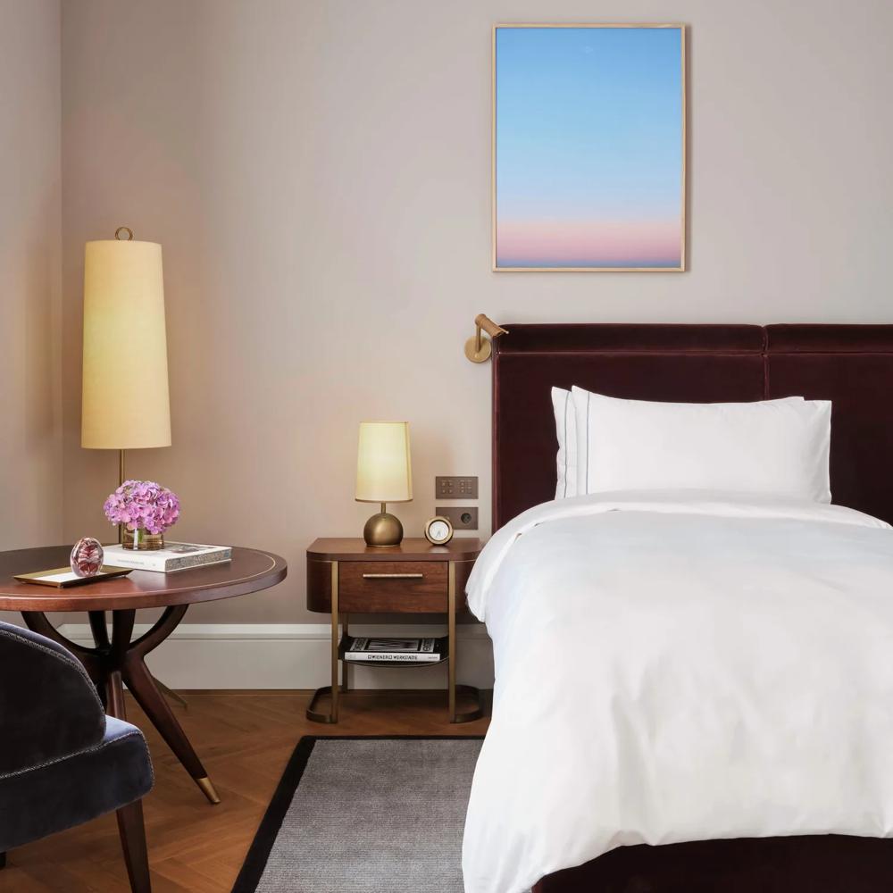 Premier Room at Rosewood Vienna featuring a plush bed with crisp white linens, elegant bedside lighting, and a cozy seating area for refined relaxation.