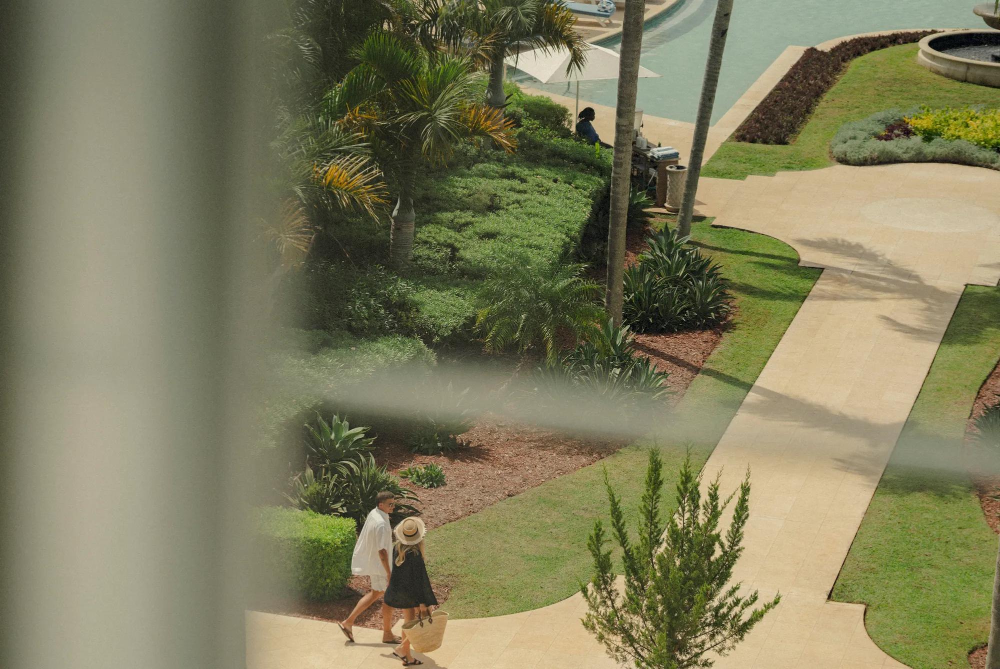 A couple walking to the pool along green paths