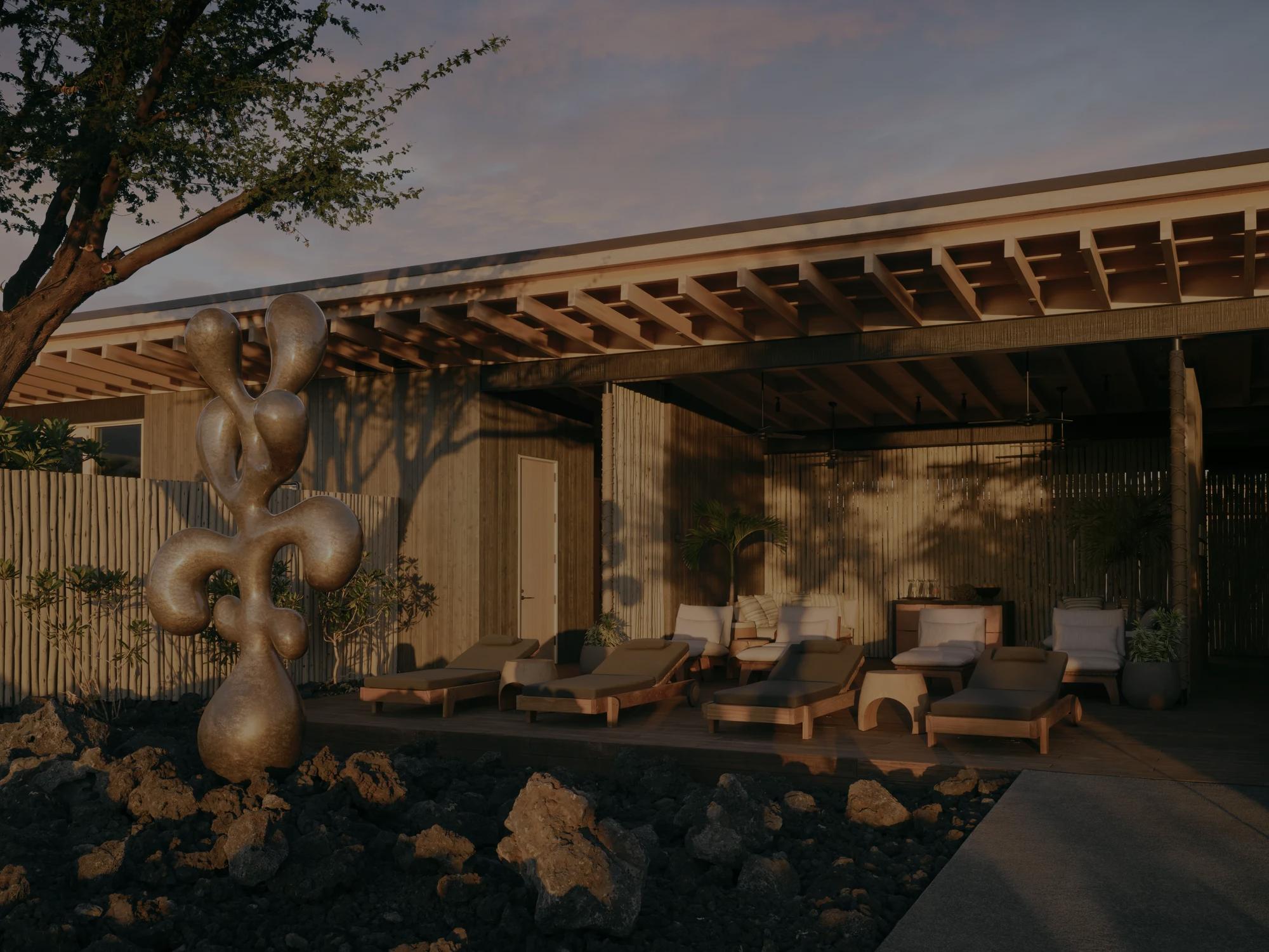 Lounge chairs on a patio facing a lava field at sunrise.