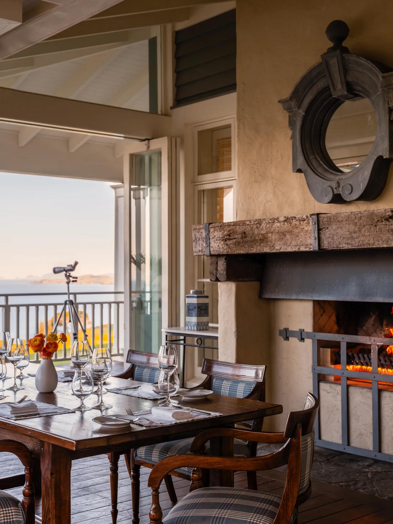 Dining set up with open doors to a private balcony and views of the Pacific Ocean