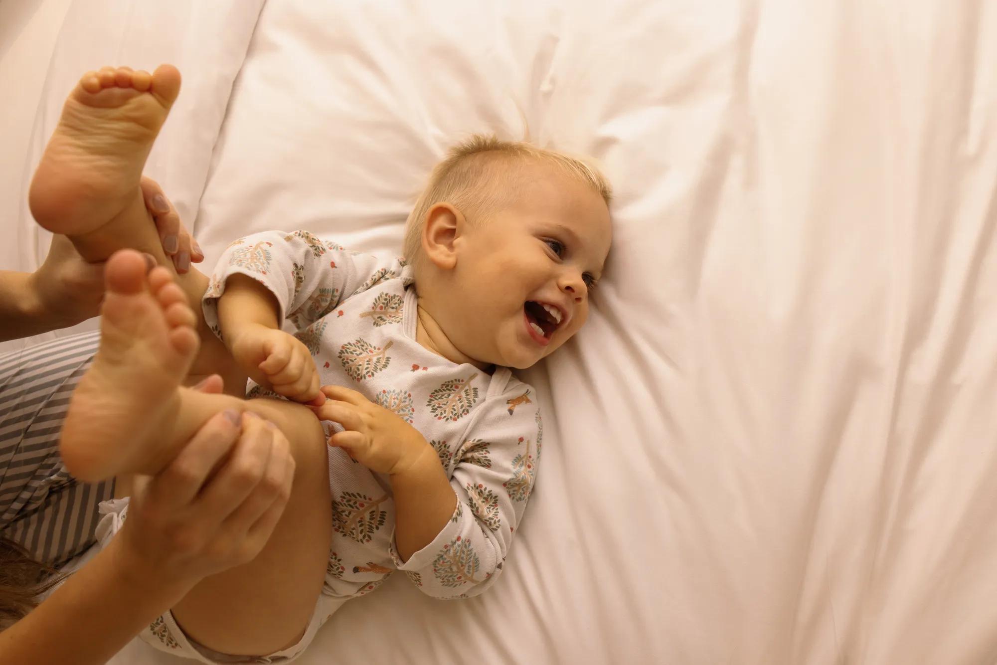 Child on bed laughing in townhouse