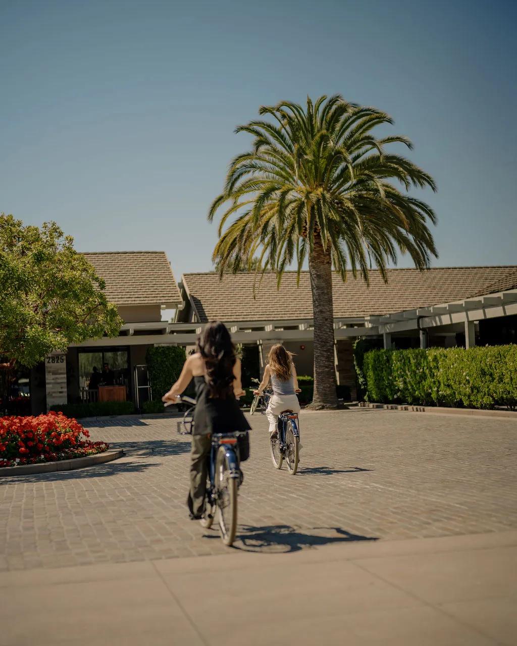 Two people riding on Bluejay Electric Bikes towards the front of Rosewood Sand Hill