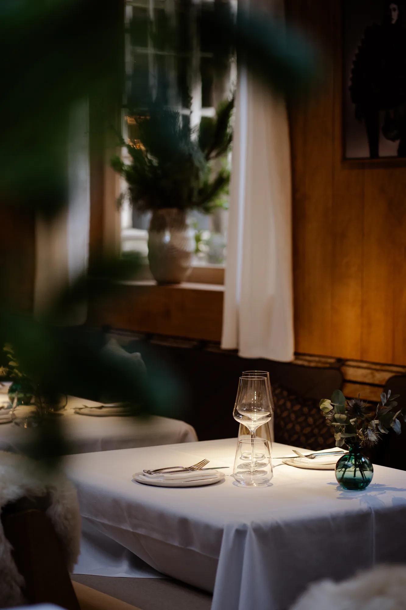 Winter terrace of The Chalet with tables and sheepskin covered chairs under a partially glazed roof.