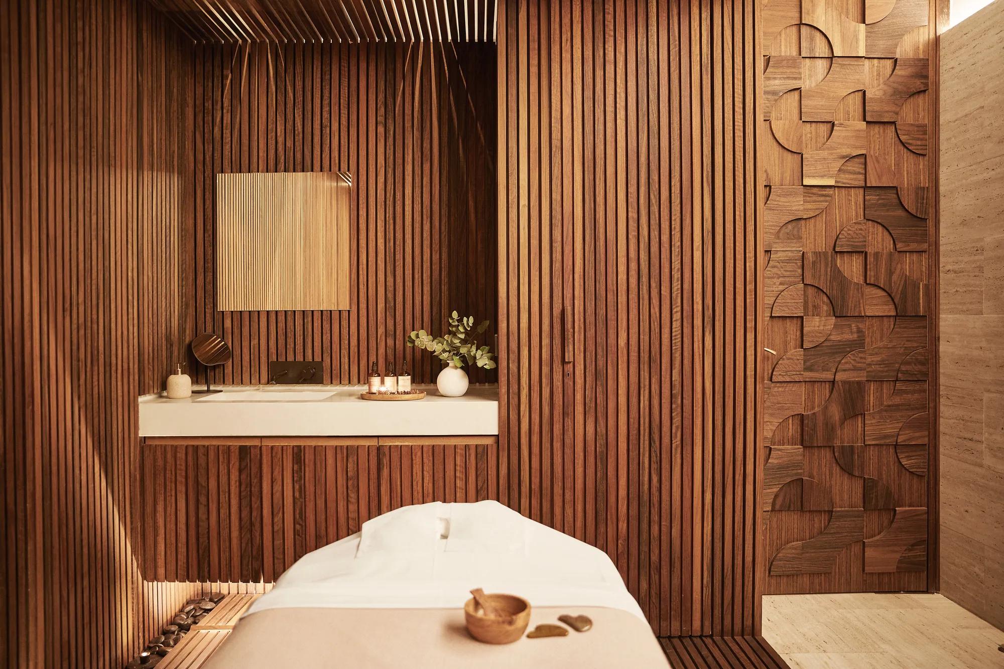 Spa cabin with wooden walls, elegant decorative details, and a massage bed, offering a warm and tranquil setting for relaxation