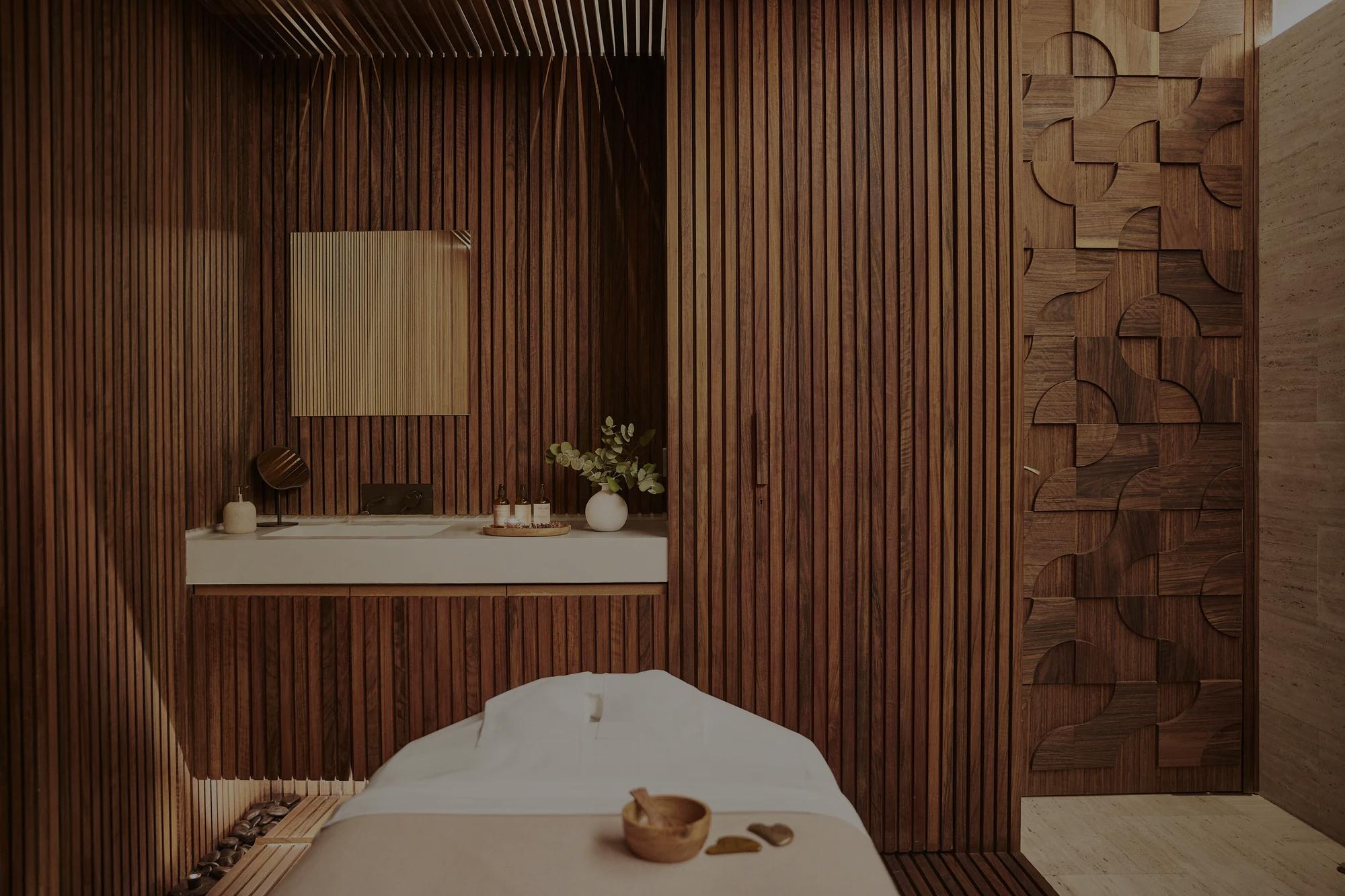 Reception area of Sense, A Rosewood Spa in Madrid, featuring a serene, softly lit space with natural textures, elegant floral arrangements