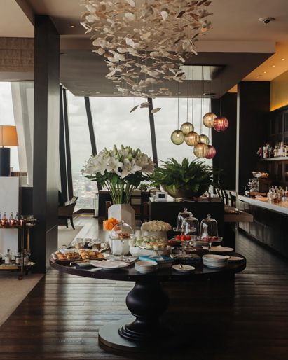 Dining area in a luxury  Phnom Penh hotel with  sculptural chandelier and  dessert buffet table. 