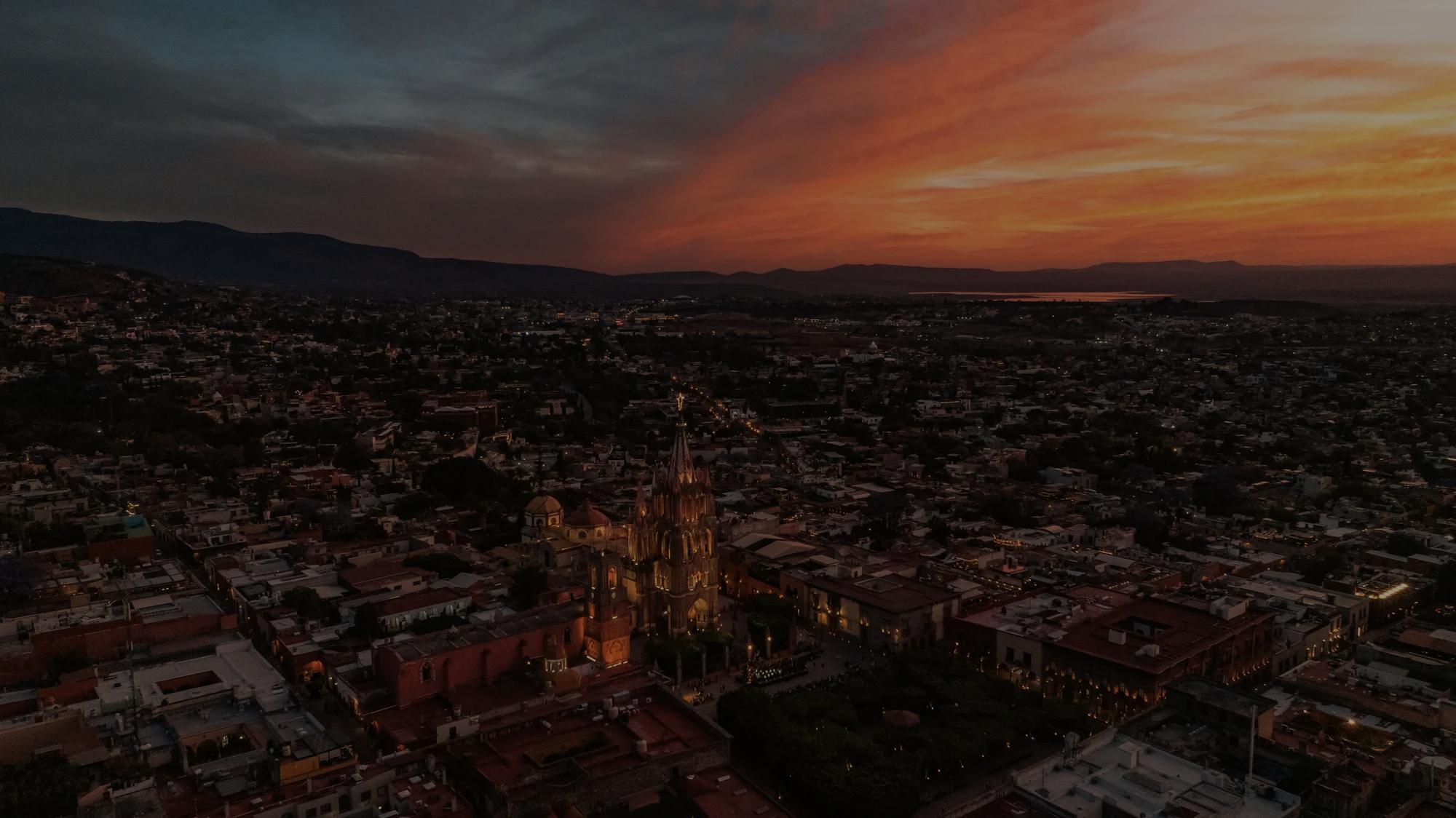 Aerial view of the Parroquia de San Miguel Arcángel surrounded by the colorful colonial buildings of San Miguel de Allende.