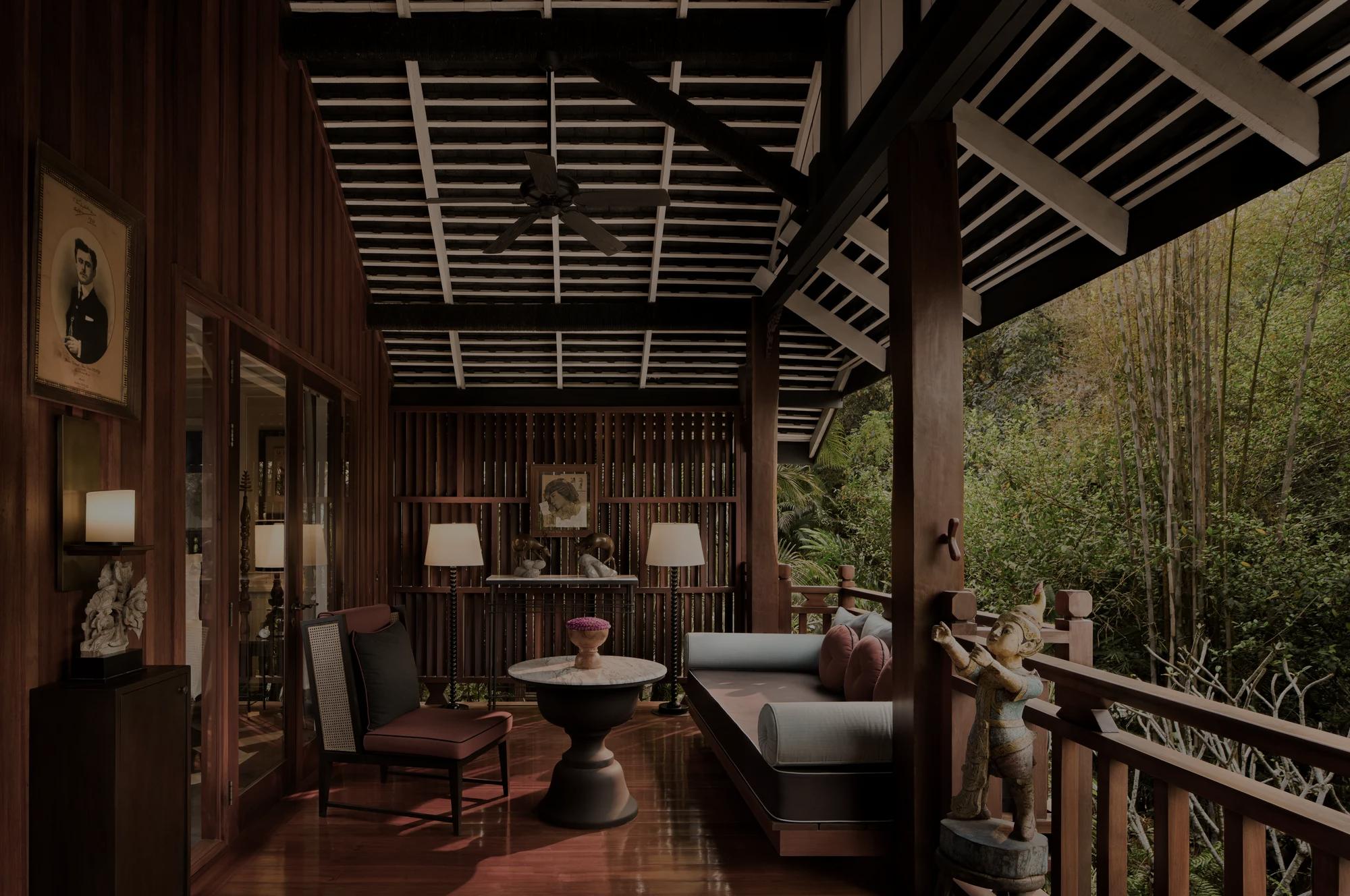 Open-air lounge with wooden beams and polished floors at a luxury hotel in Luang Prabang.