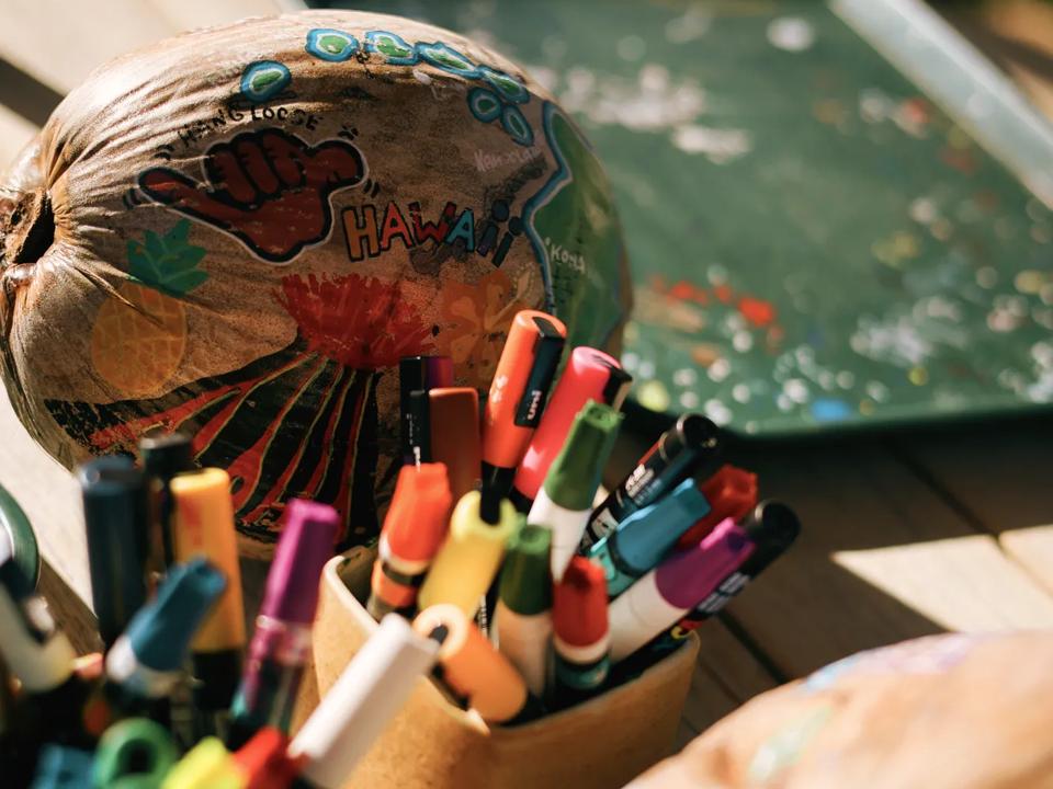 Decorated coconuts on a table with markers