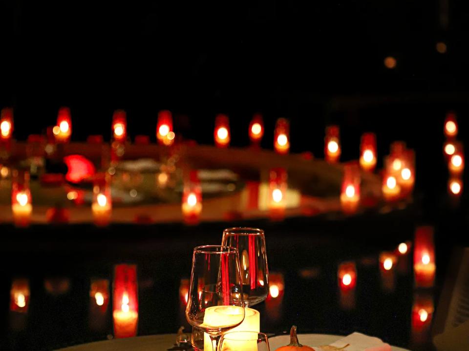 Fine dining setting surrounded by candles and halloween decorations