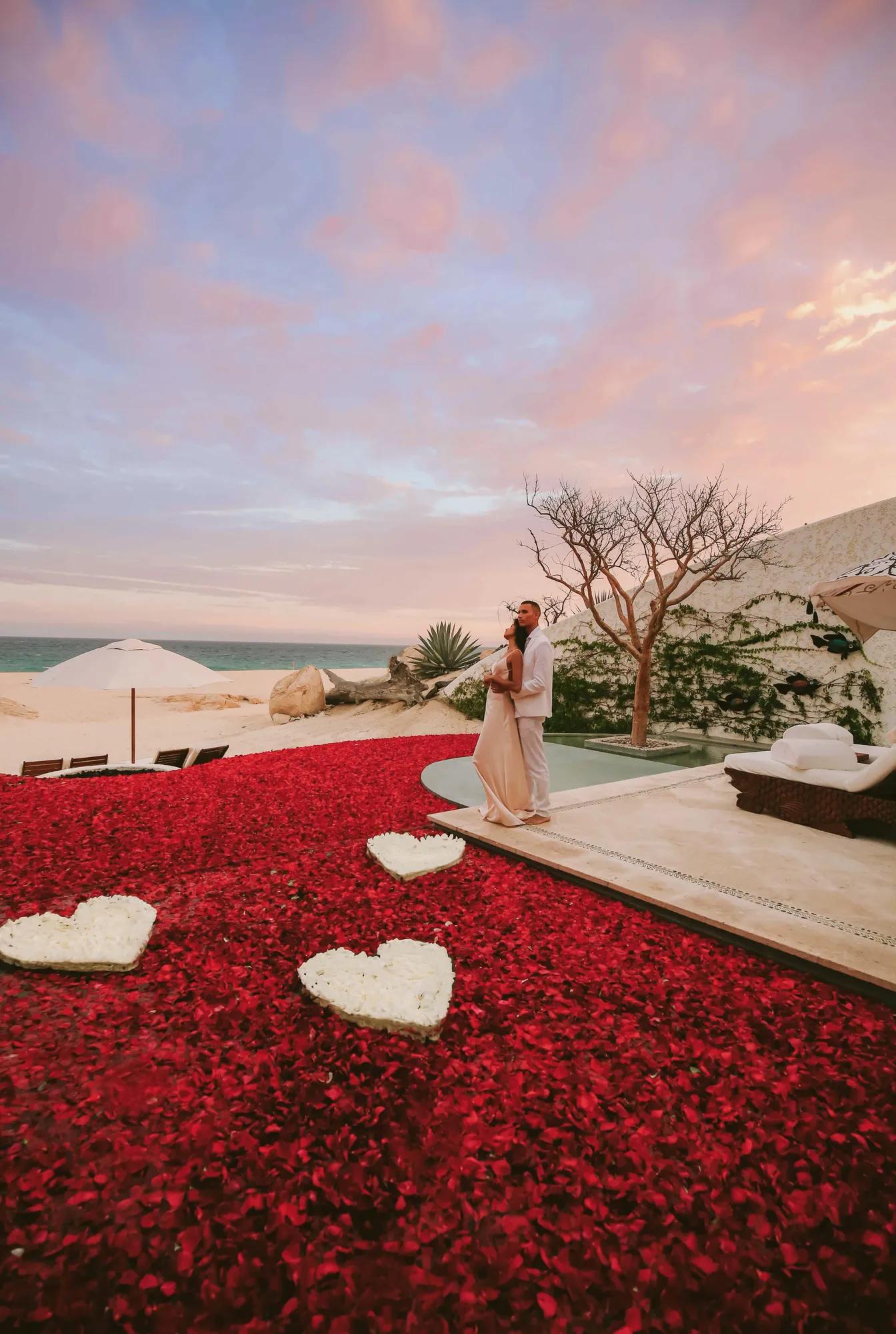 Couple in a private pool fullfill with rose petals