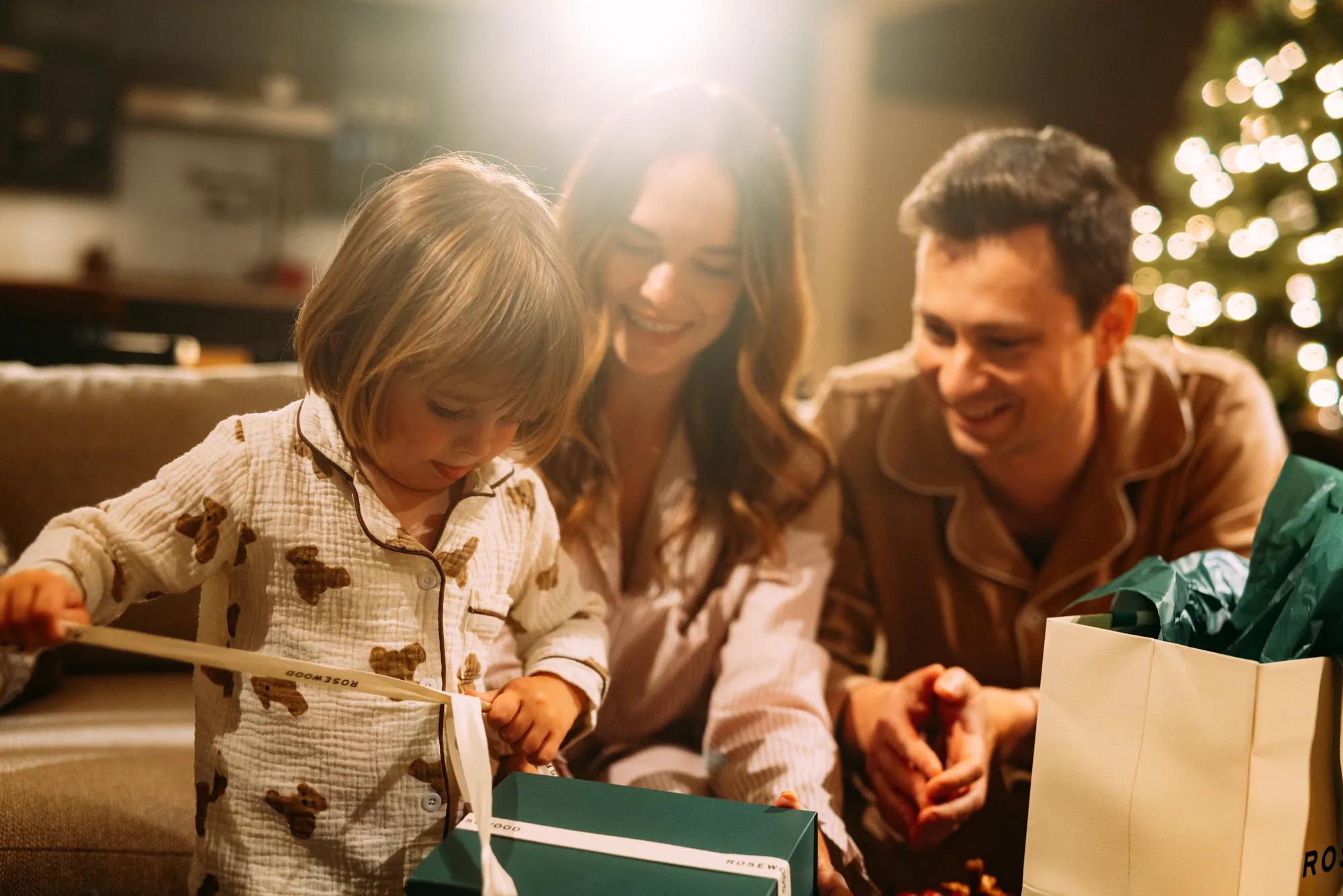 Family unwrapping a gift in a luxury villa at Rosewood Sand Hill.