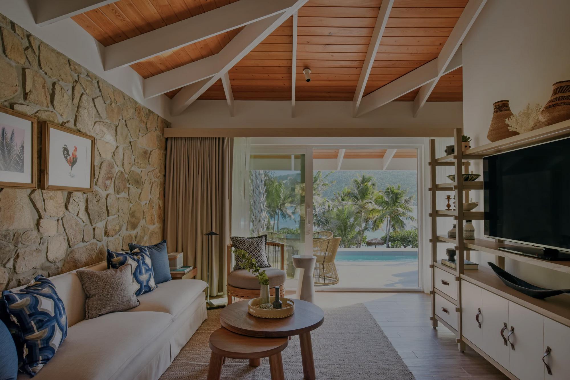One Bedroom Pool Suite with stone wall and a vaulted wood ceiling.