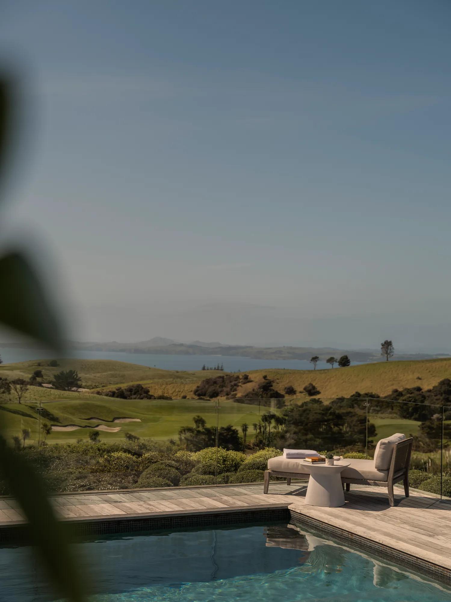 Luxury villa outdoor pool with sun loungers overlooking a golf course and ocean