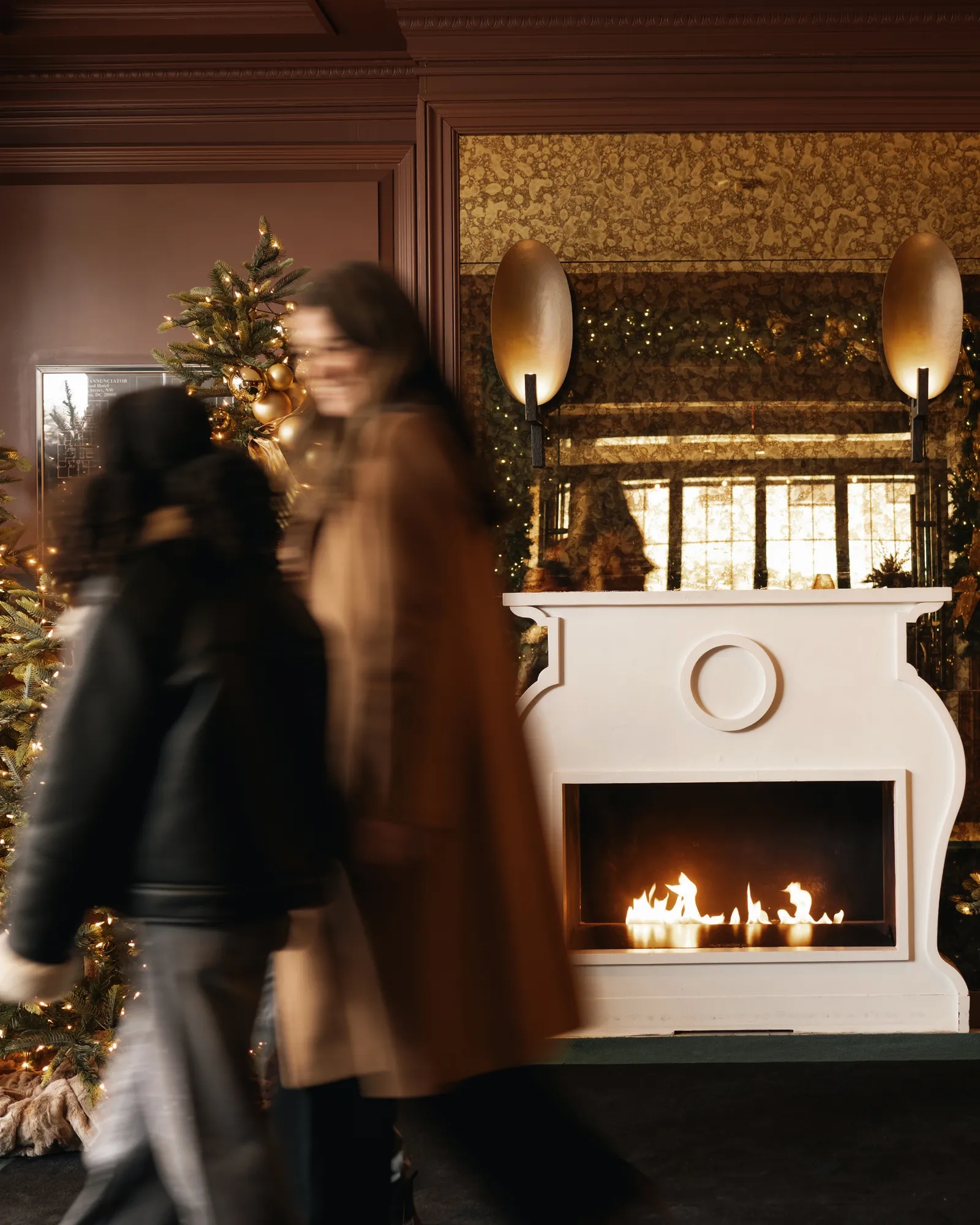 festive decor at rosewood washington, d.c. with fireplace and guests in view