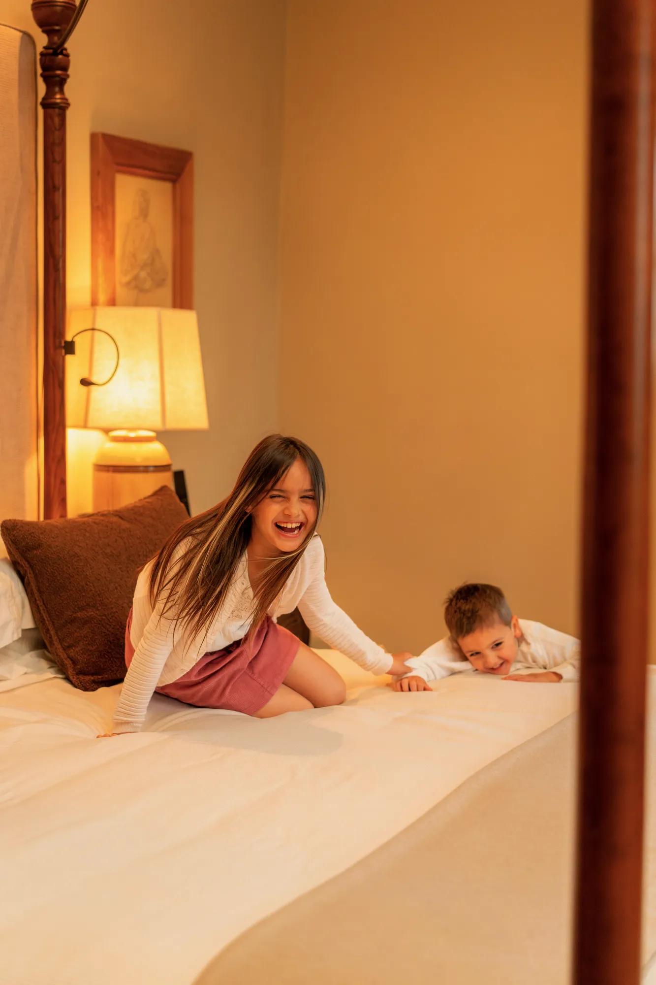 Kids jumping on a villa bedroom bed.