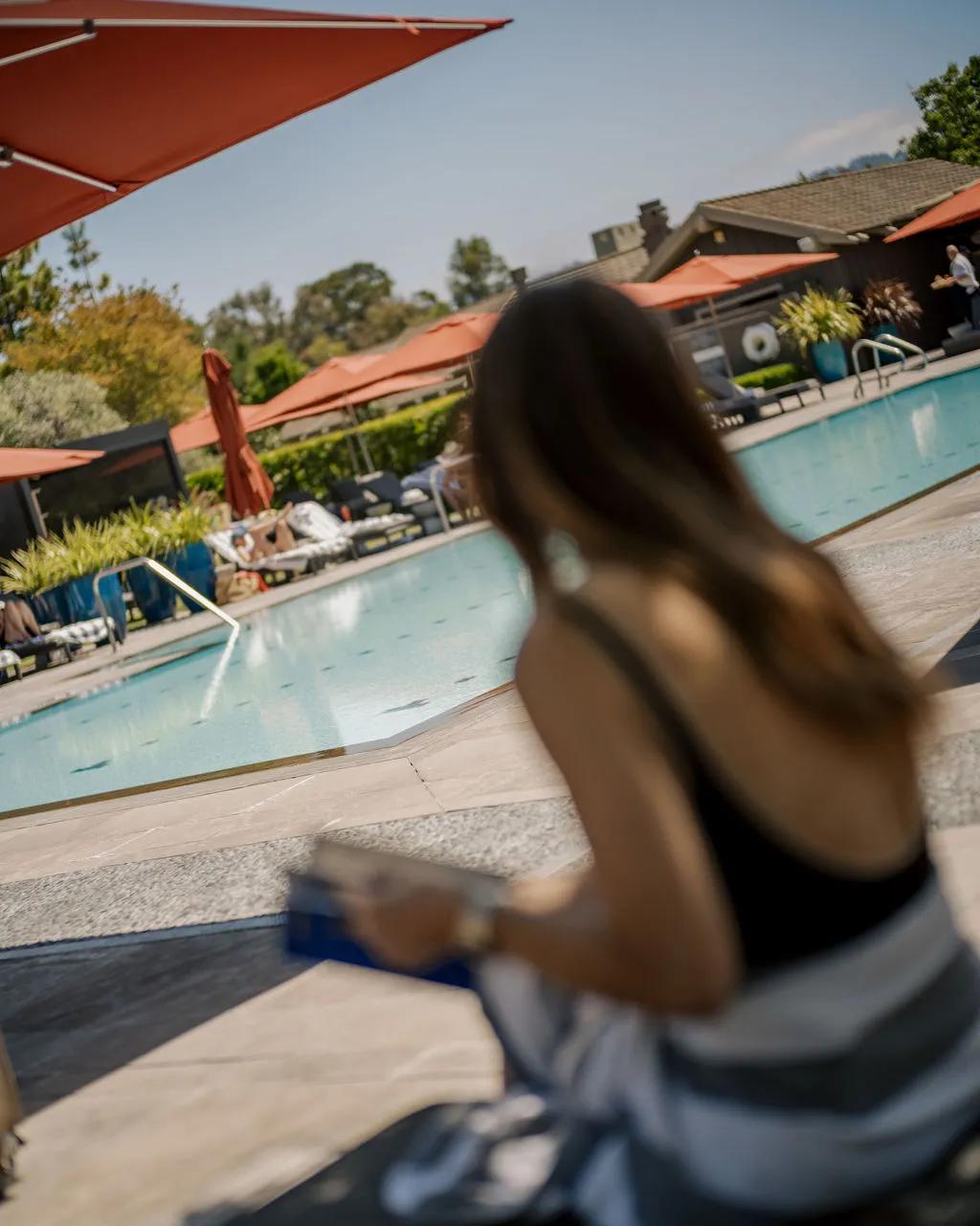 Woman sitting in front of pool background, somewhat defocused