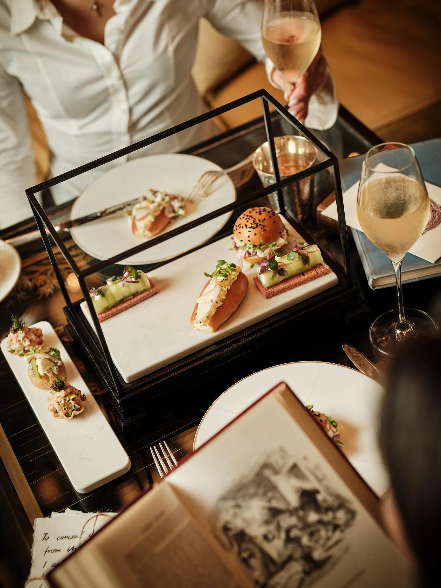 An art afternoon tea being enjoyed at Rosewood London, with sandwhiches and tea