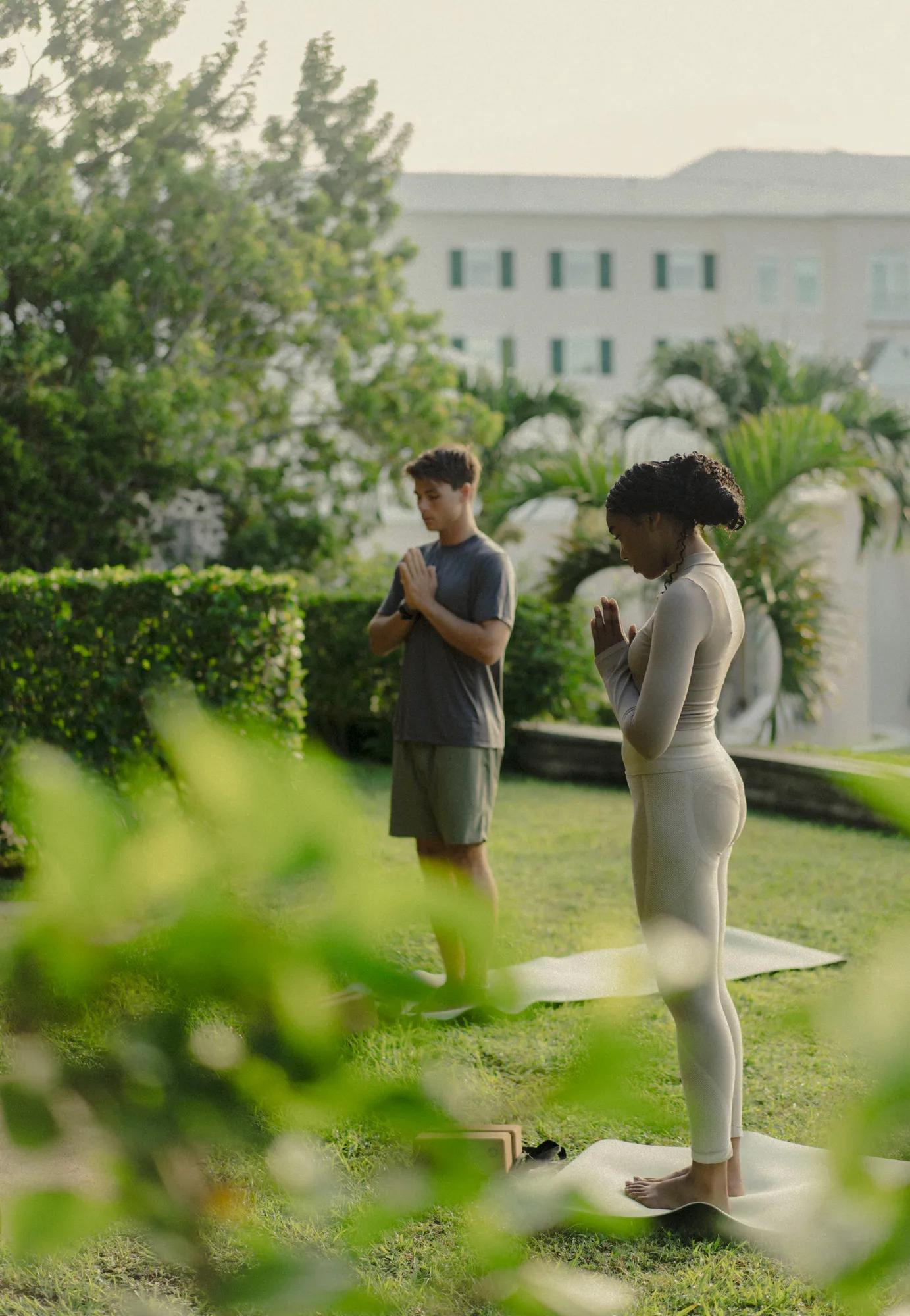 A couple taking a yoga class surrounded by greenery